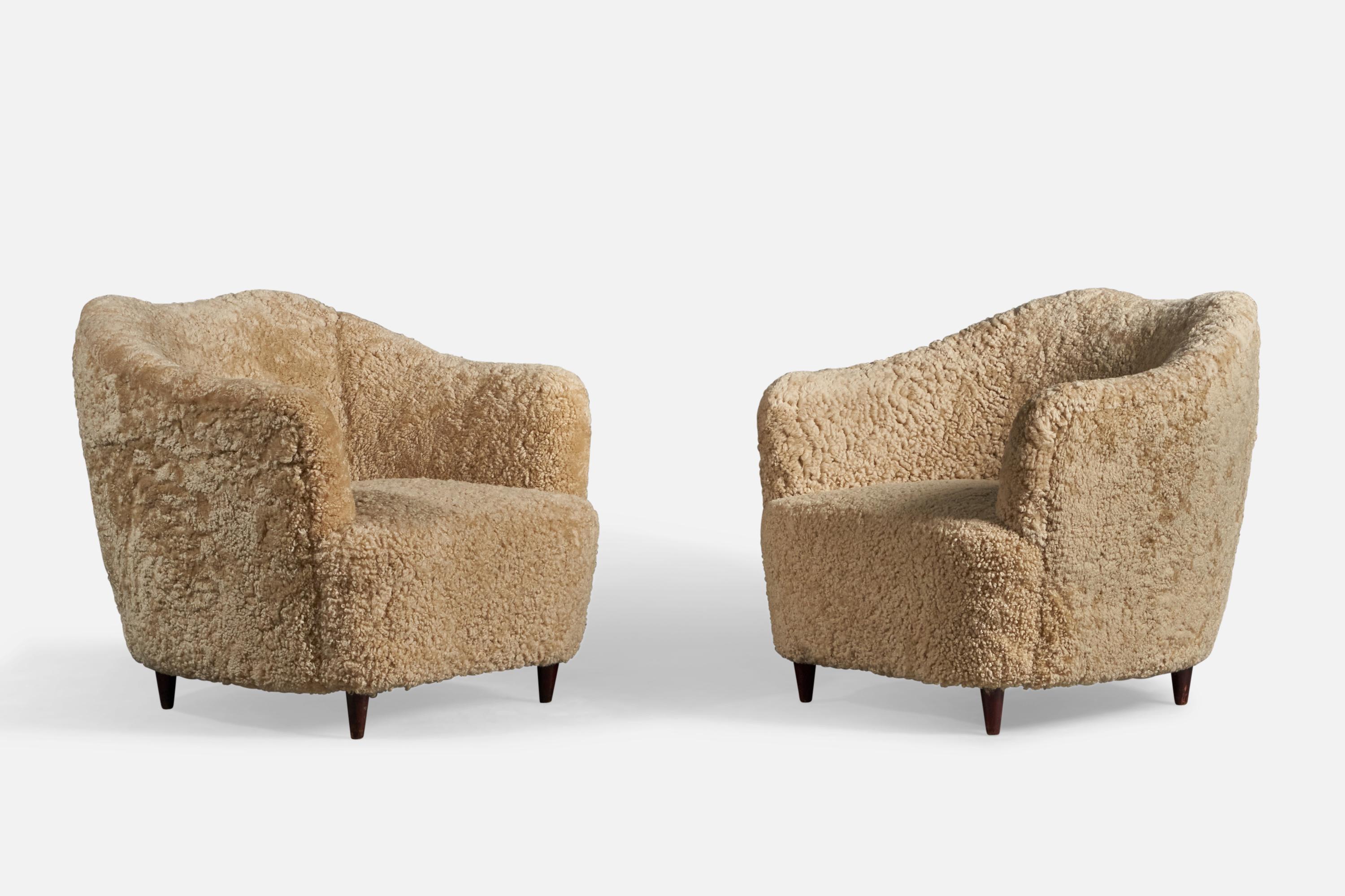 A pair of beige shearling and dark-stained wood lounge chairs, design attributed to Gio Ponti, presumably manufactured by Casa e Giardino.

14.5 seat height
