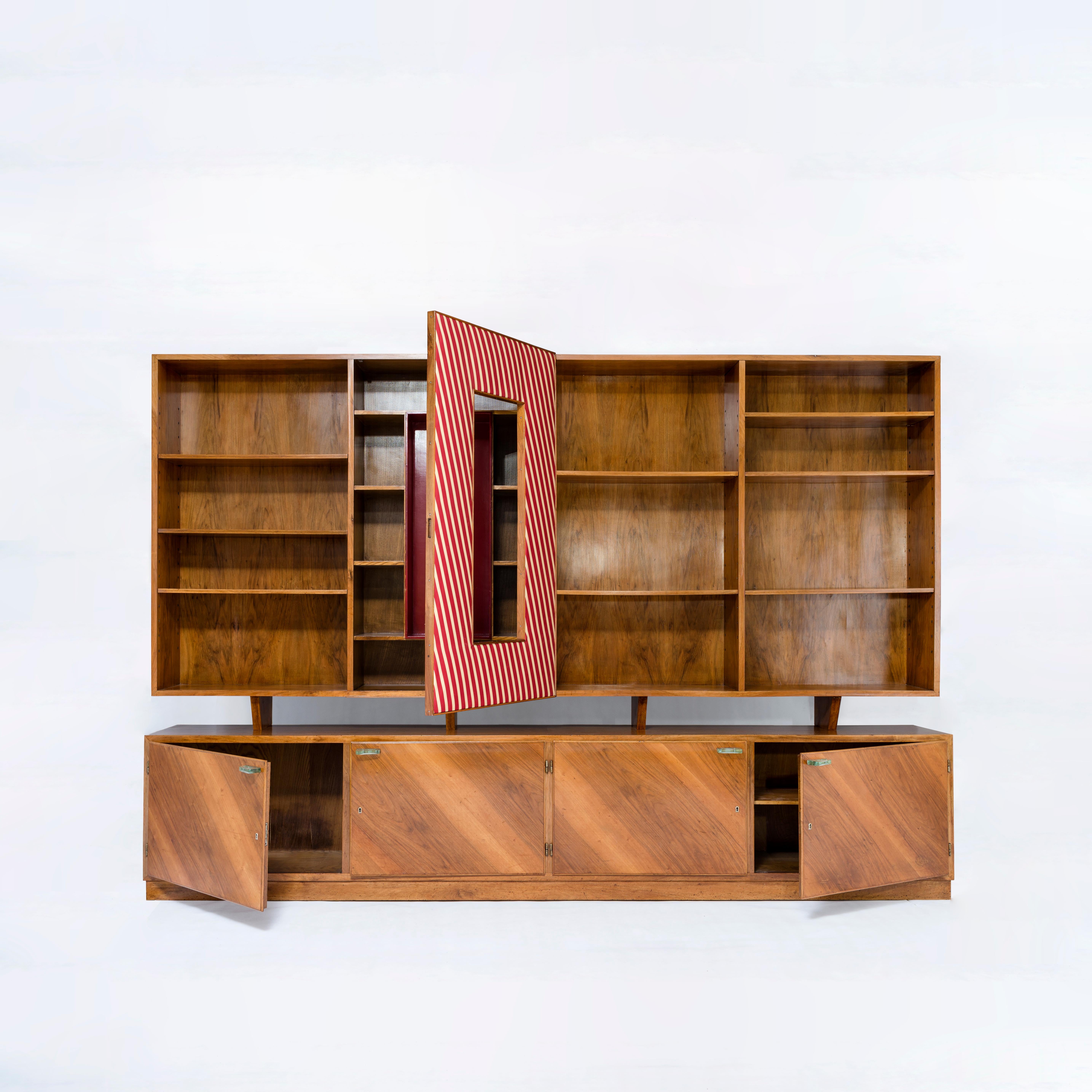Gio Ponti
Library from the private residence of an Italian collector
A certificate of expertise from the Gio Ponti archives is provided.
Walnut, silk, glass
Handles by Fontana Arte
Central doors upholstered in striped silk.