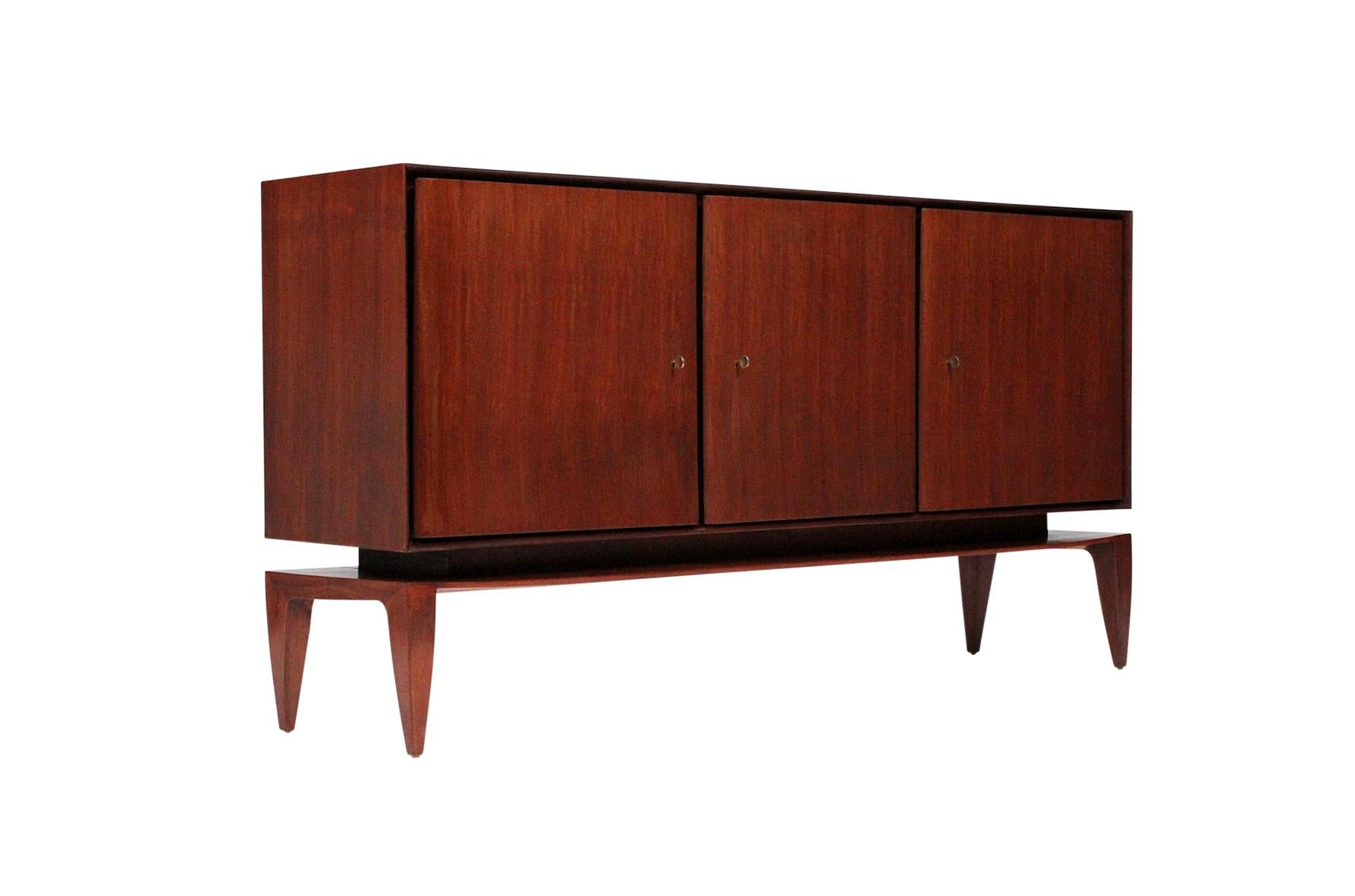 Rare three-door cabinet by Gio Ponti for M. Singer & Sons. Mahogany cabinet raised on tapering legs. Interior drawers and shelves. This cabinet was handmade in an Italian workshop and marketed in the States through M. Singer & Sons. Cabinet is in