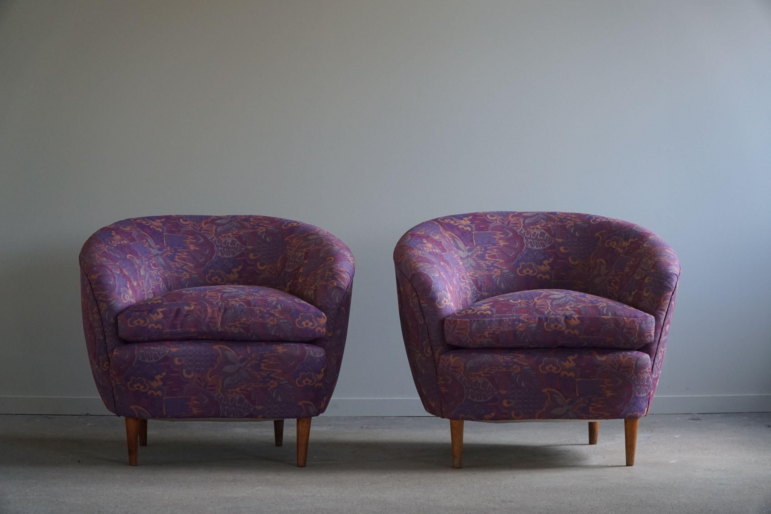 A magnificent pair of curved club chairs, reupholstered in a luxurious vintage fabric stored from the 1980s. This nicely patterned fabric really complements the soft curves. Made in the style of the world known Italian Designer Gio Ponti in the