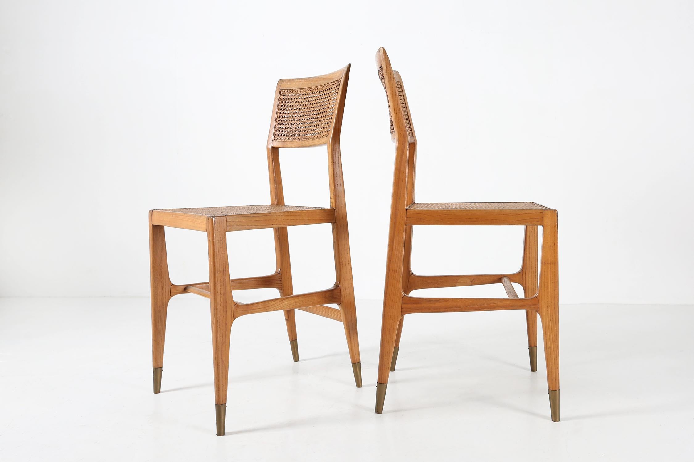 Set of two chairs designed by Gio Ponti in 1951 exclusive for the San Remo Casino.
In natural ash wood with seat and back in woven cane, Legs with brass tips.

These rare chairs are made to sit on the roulette table. The seat height is slightly