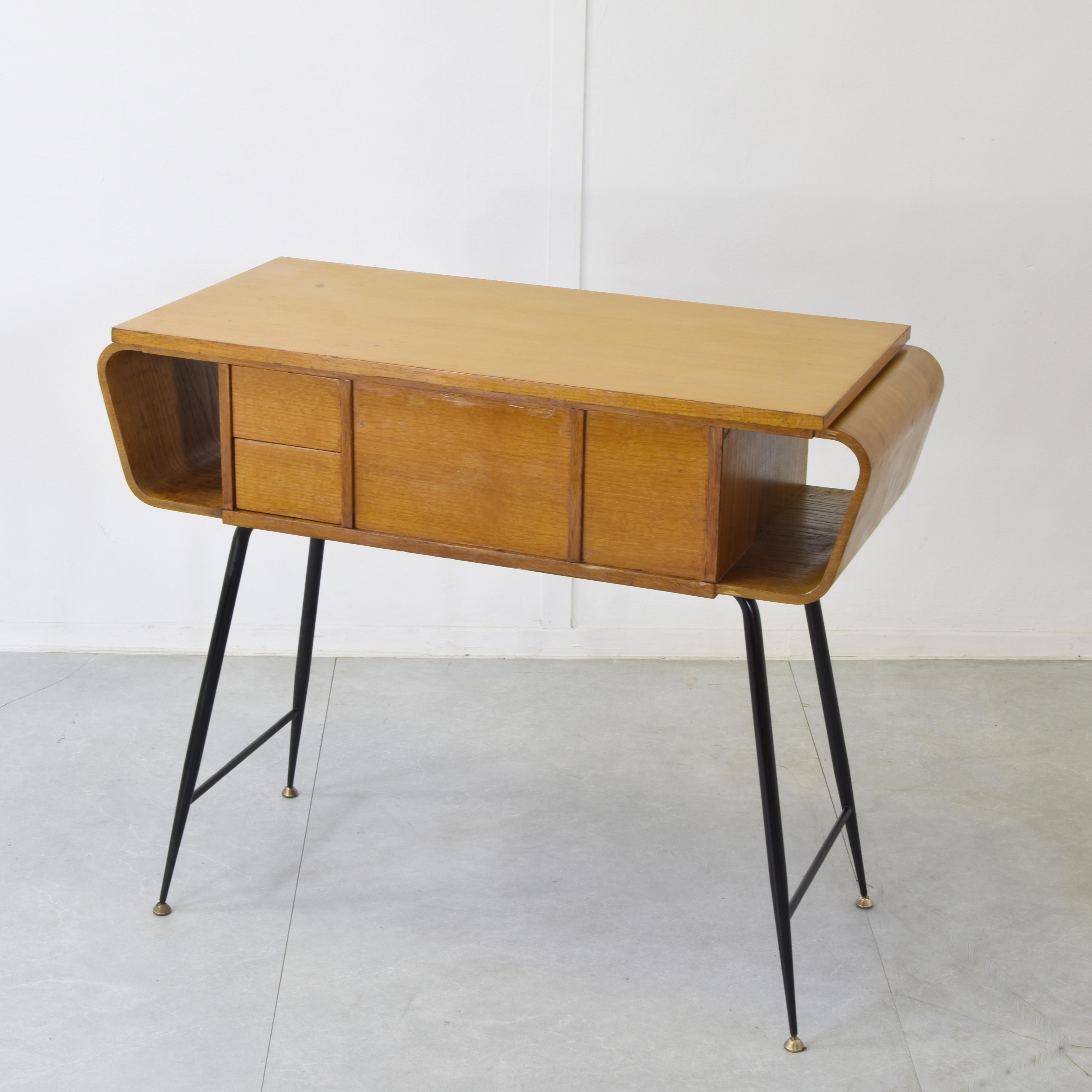 Raro esempio di design industriale elevato, questa consolle di Gio Ponti per Singer degli anni ’60 unisce funzionalità e grazia formale. Realizzata in quercia laccata, presenta gambe in ferro nero con raffinati piedi in ottone. Il piano apribile e i