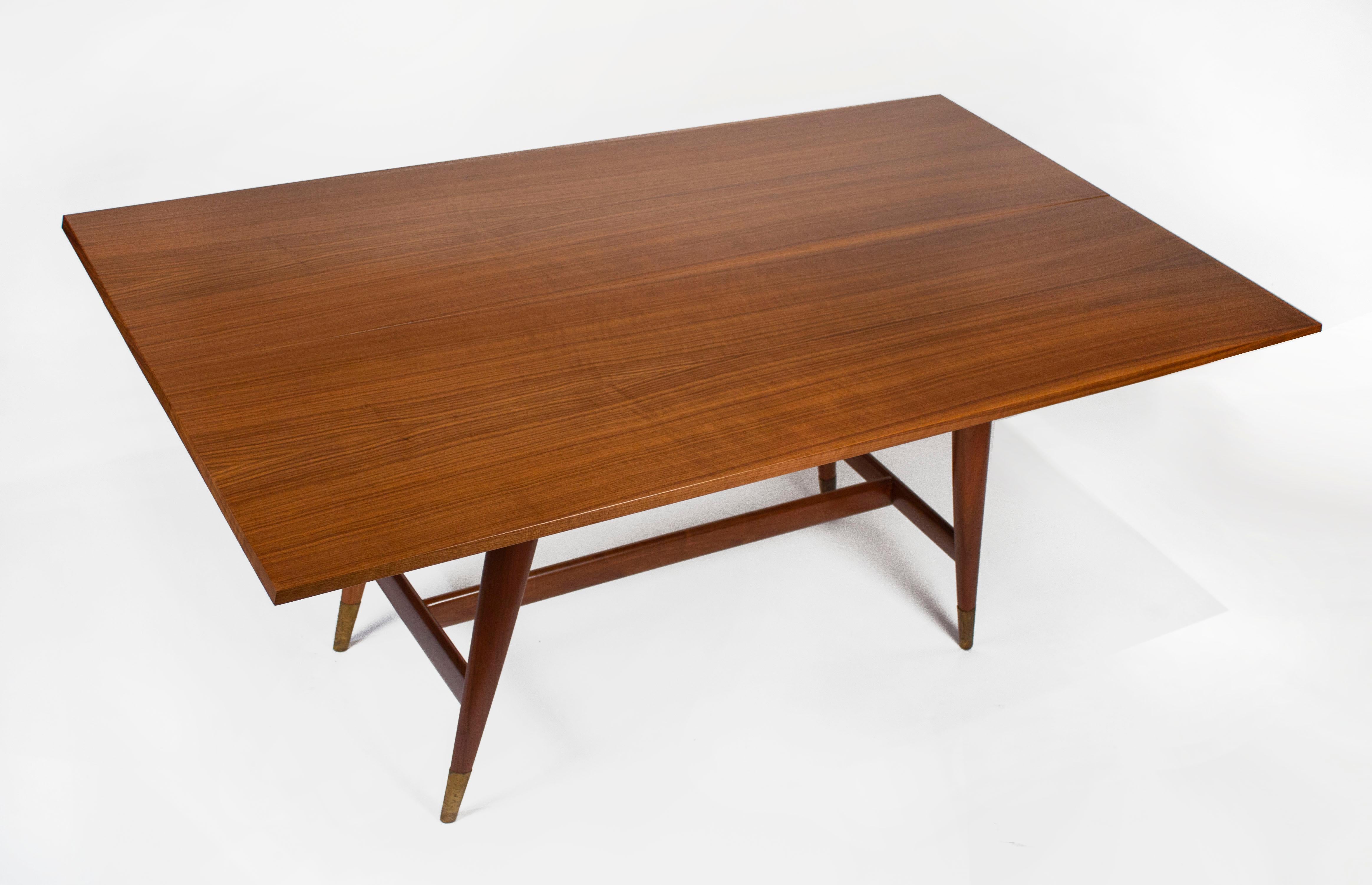 Vintage Model 2134 Italian walnut flip-top table designed by Gio Ponti for M. Singer & Sons.
Two book-matched Italian walnut tops with beveled edges connected with recessed hinges over solid walnut tapering legs with brass sabots. The tops easily
