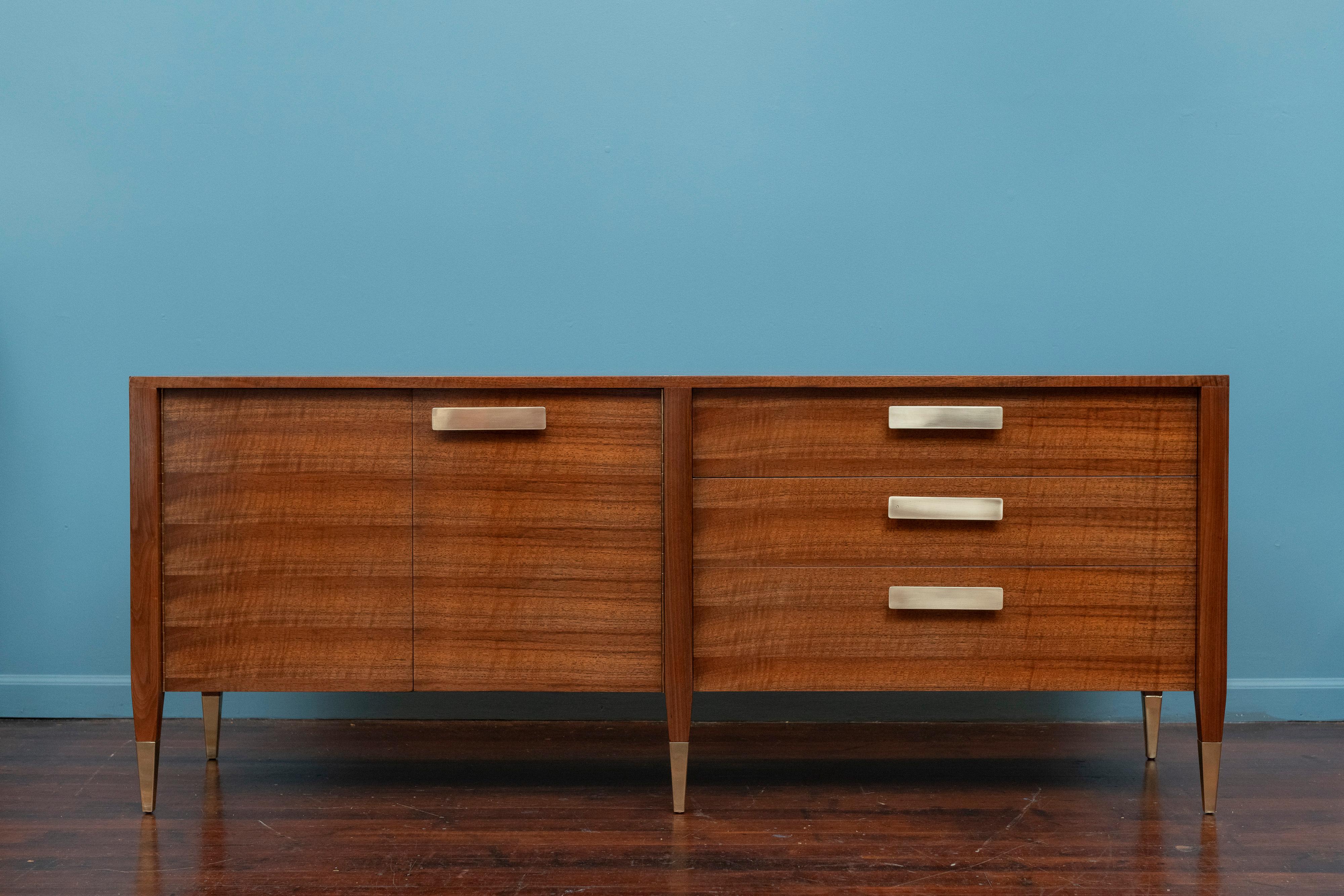 Gio Ponti design credenza or cabinet for Singer & Sons, Model 4120. Sophisticated design credenza by the master Gio Ponti for Singer & Sons executed in gorgeous Italian ribbon walnut with brass pulls and sabots. Featuring two doors, an adjustable