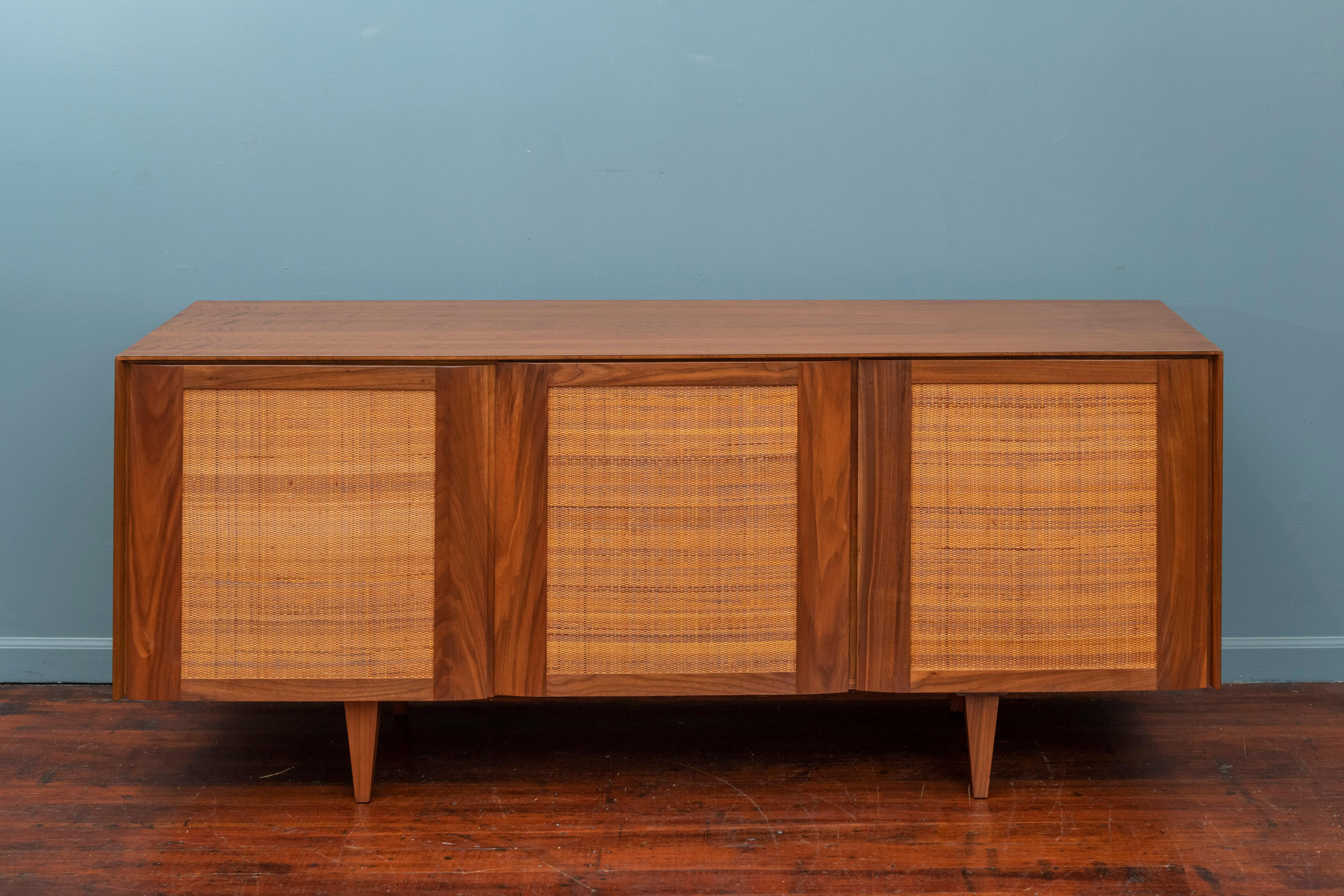 Gio Ponti credenza for M.Singer & Sons, Model 2184. Highly quality construction with gorgeous figured walnut case and doors on original tapered legs. Original caned doors with a fitted interior comprising four drawers and one shelf. Lightly