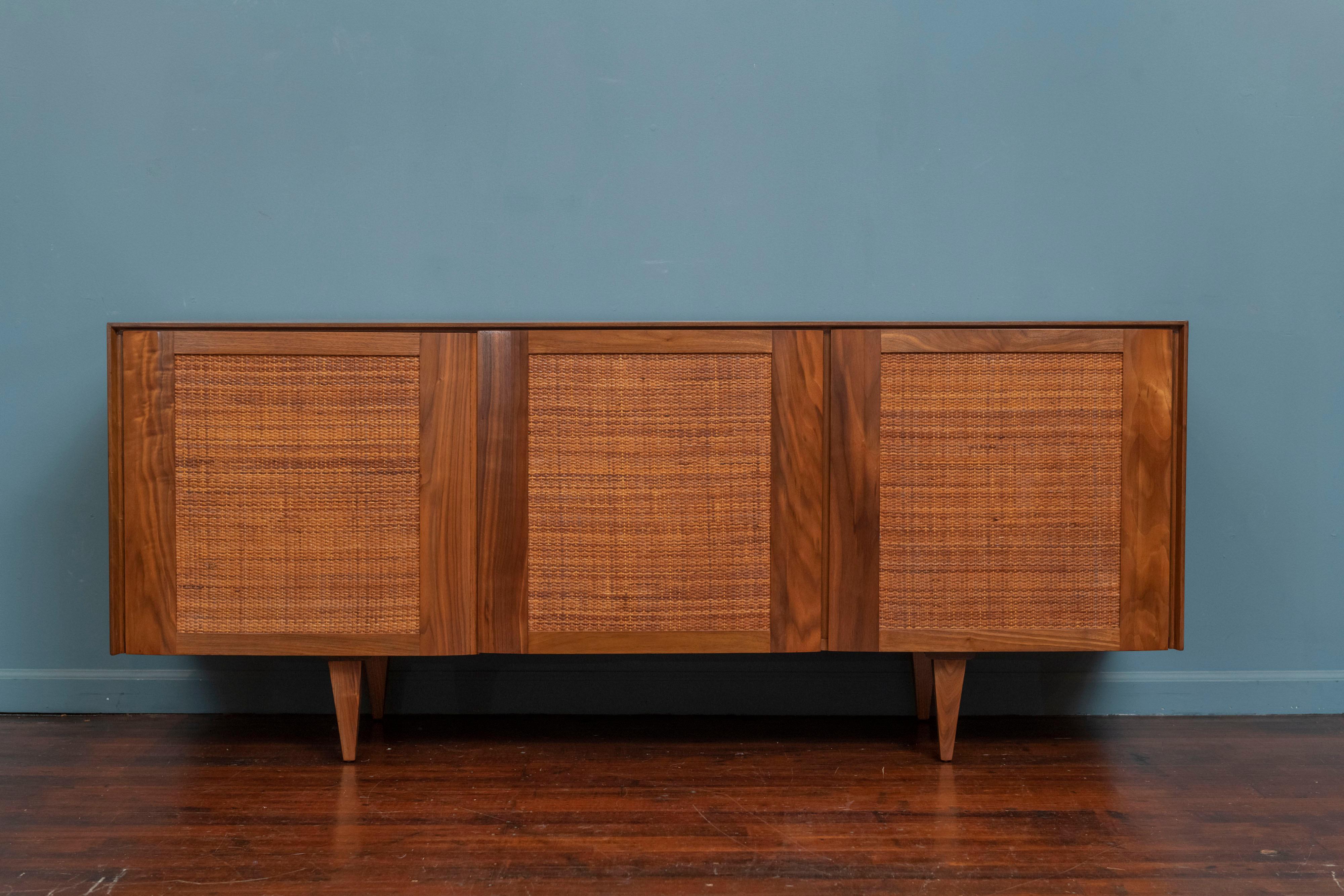 Gio Ponti design credenza for M.Singer & Sons, Model 2184. Highly quality construction with gorgeous figured walnut case and doors on original tapered legs. Original caned doors with a fitted interior comprising a large drawer and one shelf. Lightly