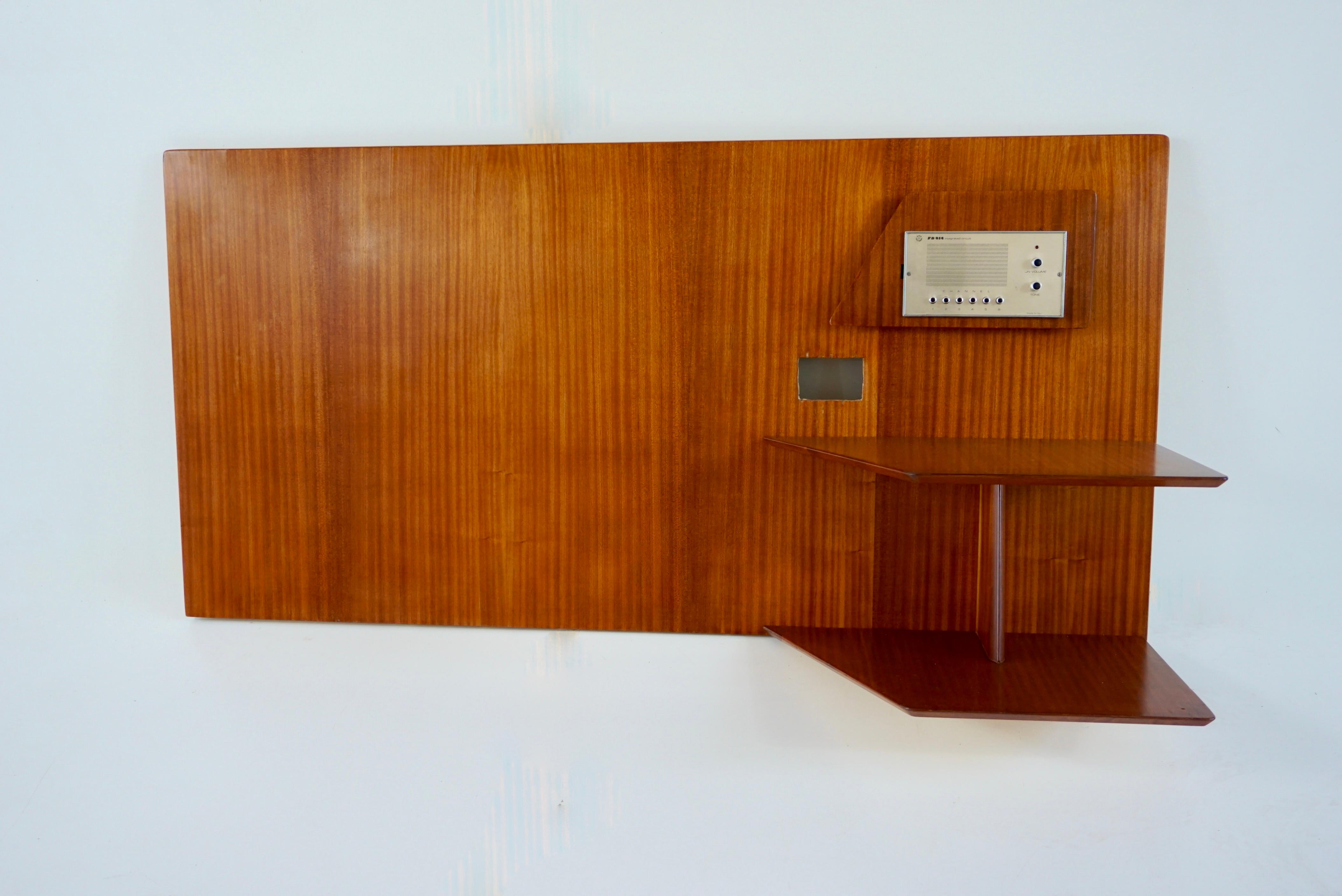 a single  left headboard by Gio Ponti from the furniture of the Hotel Royal in Naples, 1955.
Manufactured by Giordano Chiesa by Dassi.
dark honey wood  
two tiered shelving, magazine rack, space for lighting switch 
Good condition. Original patina,