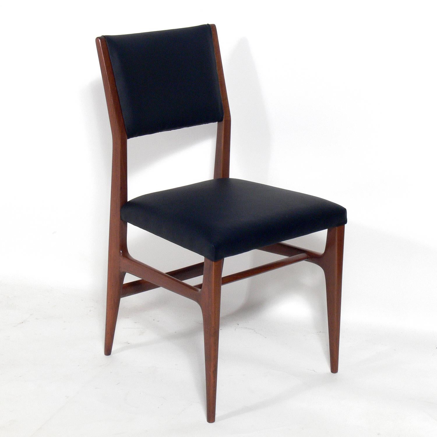 Modernist Italian dining chairs, designed by Gio Ponti for Singer and Sons, Italy, circa 1950s. They have been refinished and reupholstered in black leather. They are priced at $2800 each.