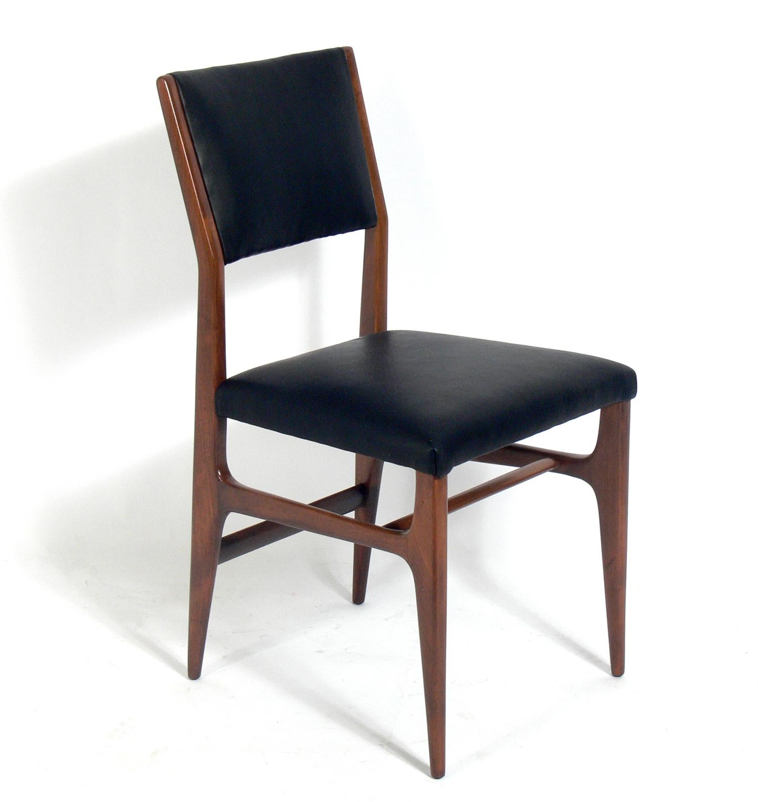 Modernist Italian dining chairs, designed by Gio Ponti for Singer and Sons, Italy, circa 1950s. They have been refinished and reupholstered in black leather. They are priced at $2800 each.