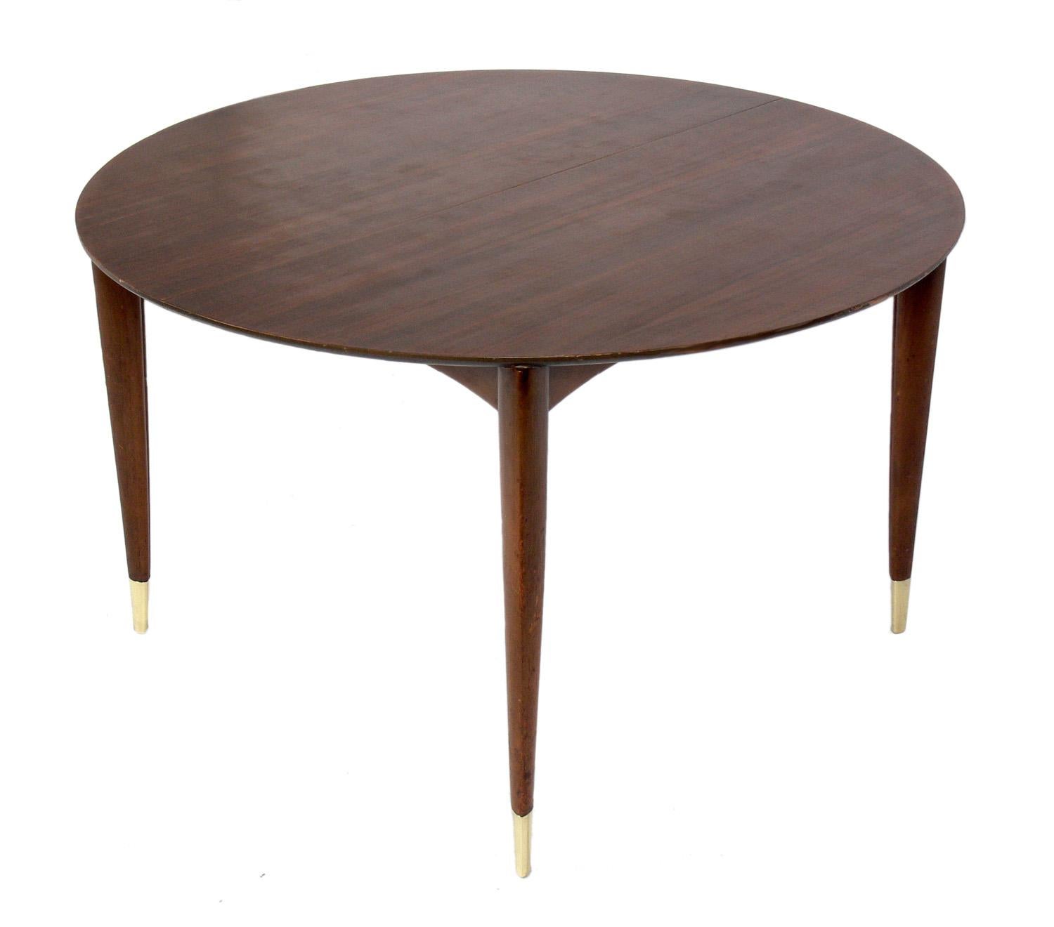 Elegant Italian walnut dining table, designed by Gio Ponti for Singer and Sons, Italy, circa 1950s. With all four leaves of it's leaves installed, the table measures an impressive 104
