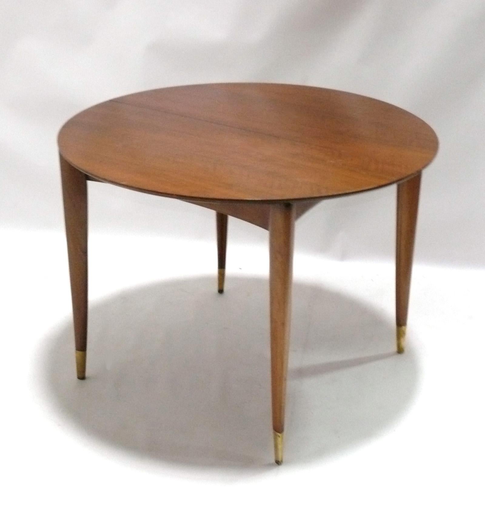 Elegant Mahogany dining table, designed by Gio Ponti for Singer and Sons, American, circa 1950s. This table is being refinished and will look incredible when completed. The brass sabots will be polished and lacquered. It expands from a 40