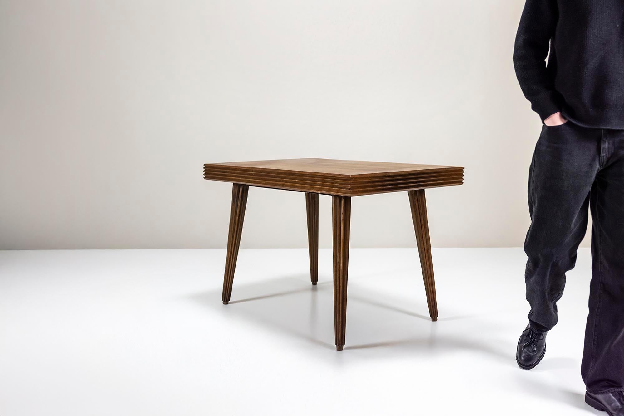 This exceptional dining table, designed by the legendary Gio Ponti in the early 1940s, is a stunning example of Italian craftsmanship and design. Featuring a rectangular top veneered in rich Italian walnut, the table exudes a sense of refined