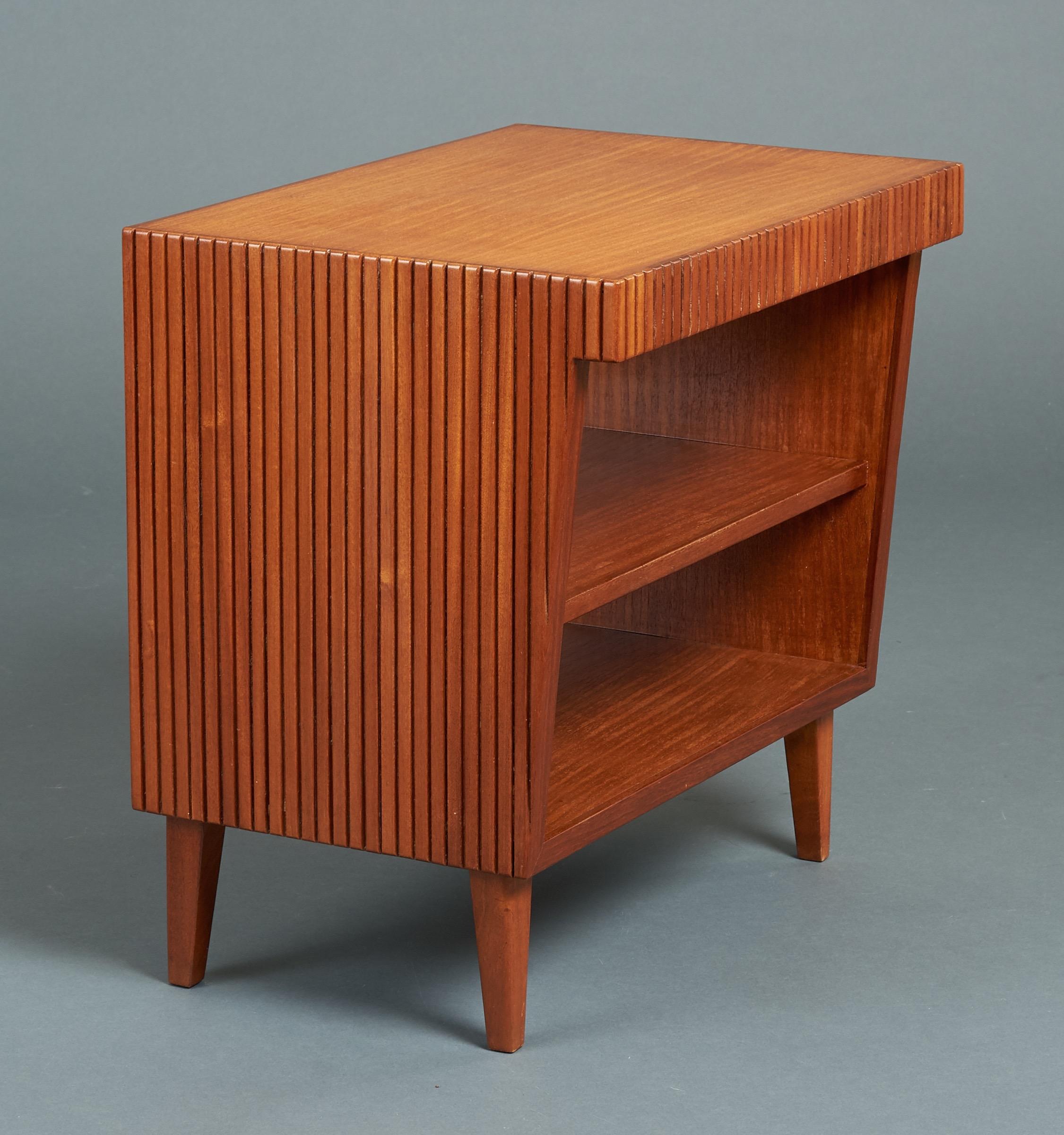 Gio Ponti (1891-1979)

A geometric side table, nightstand, or small bookcase in reeded mahogany by Gio Ponti. With two bookshelves, an asymmetrical stepped shape, and grooved carving of rich, variegated coloration, a distinct decorative feature