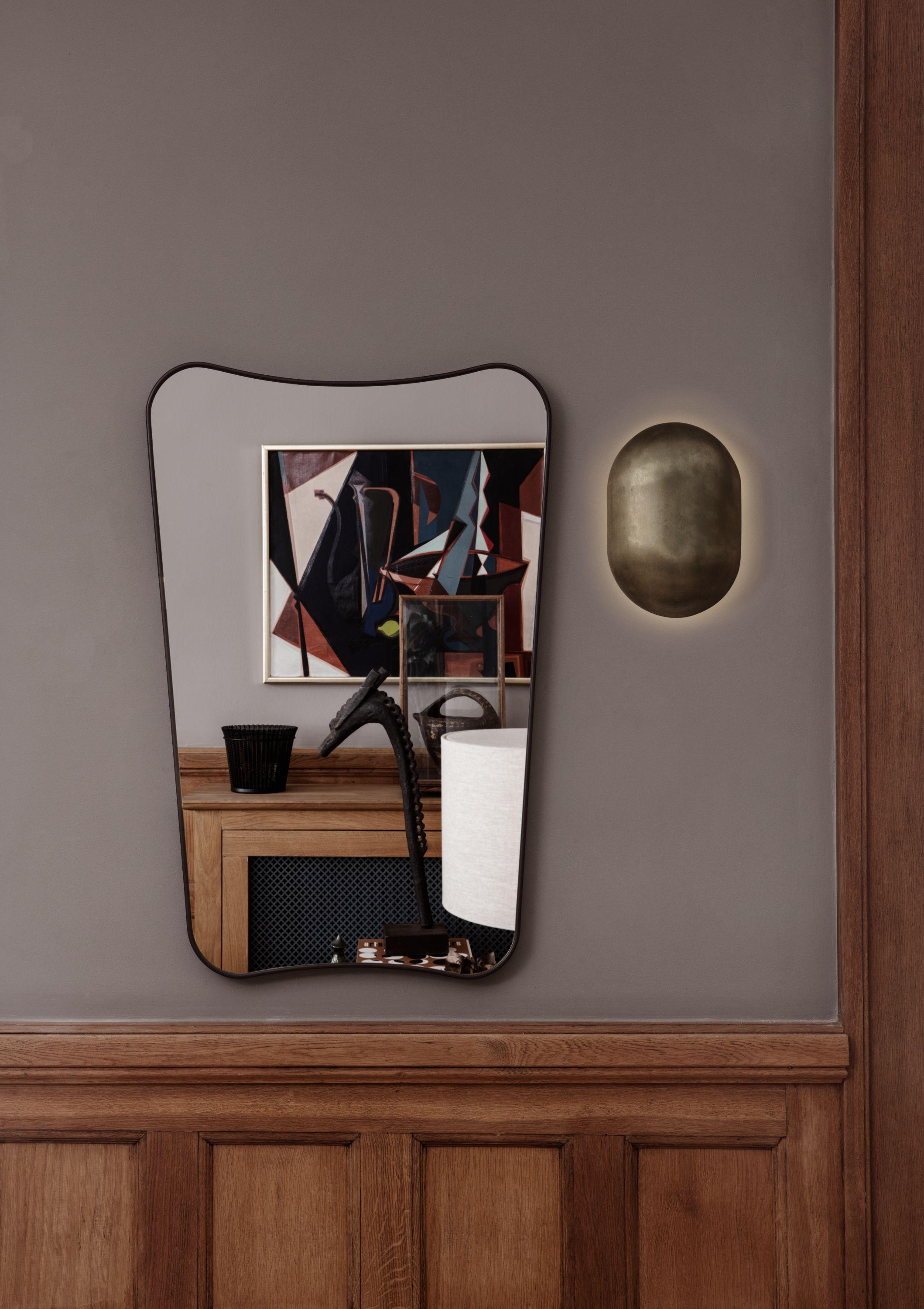Gio Ponti F.A. 33 medium mirror in black brass. The F.A. 33 Mirror was originally designed by Gio Ponti in 1933 for Fontana Arte, the period’s most prominent lamp, glass, and mirror manufacturer. Executed in brass and glass. With its curved shape