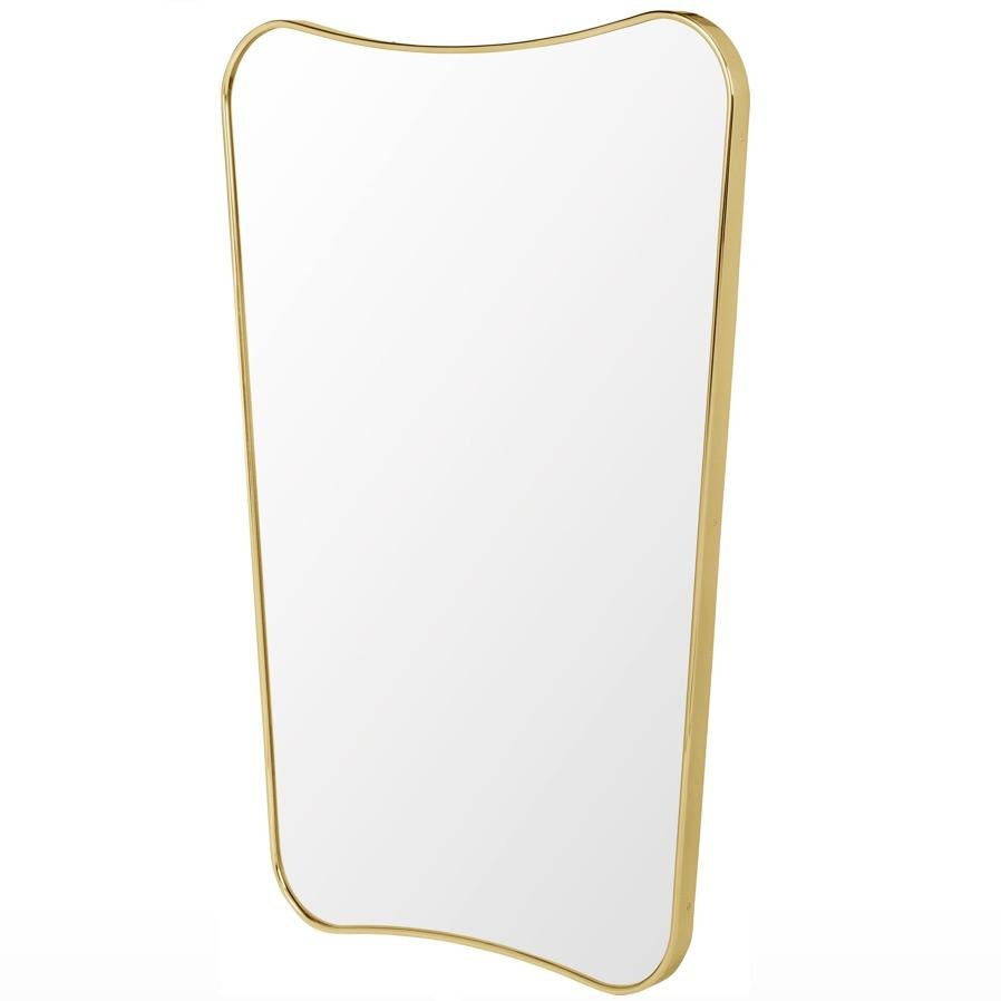Gio Ponti F.A. 33 medium mirror in brass. The F.A. 33 mirror was originally designed by Gio Ponti in 1933 for Fontana Arte, the period’s most prominent lamp, glass, and mirror manufacturer. Executed in brass and glass. With its curved shape and