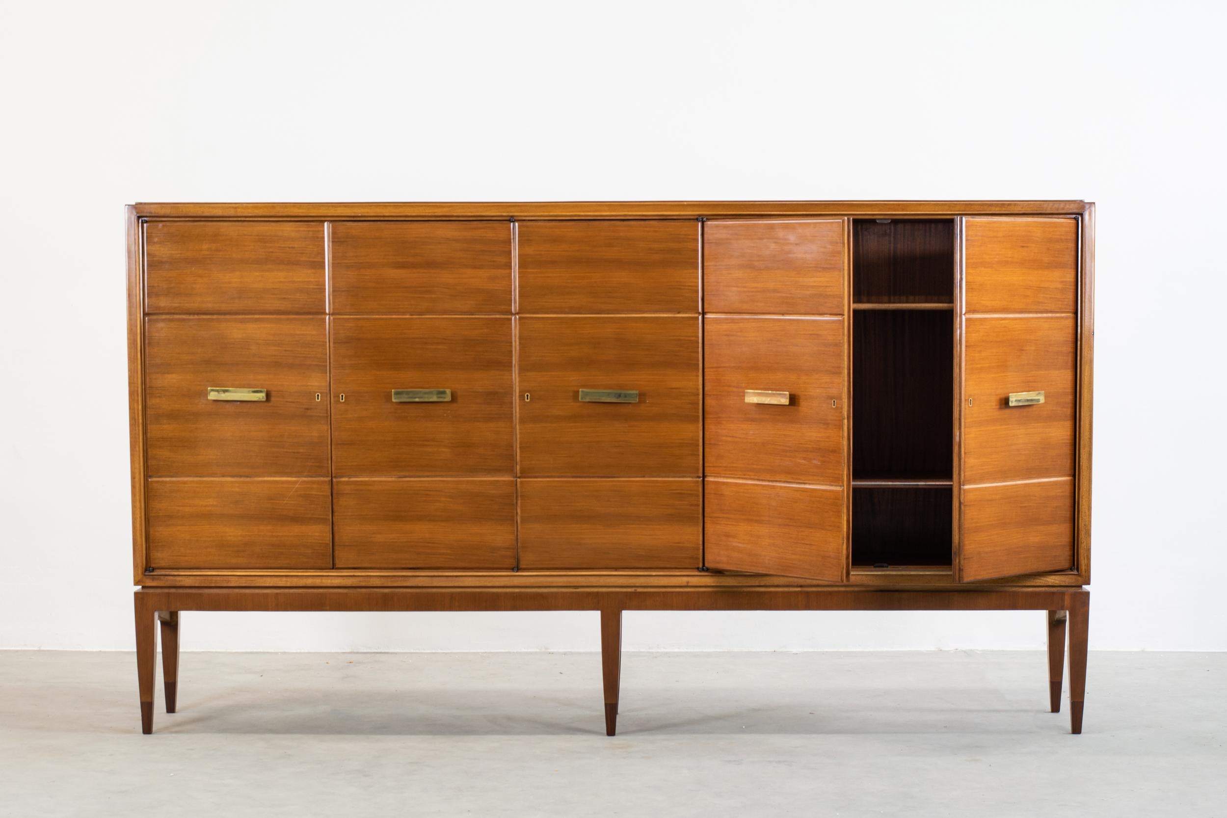 20th-Century sideboard with five doors and inner shelves in walnut veneer with brass handles and keys. 
Designed by Gio Ponti and manufactured by Singer & Son between the late 1940s and the early 1950s.
The sideboard has accompanied the authenticity