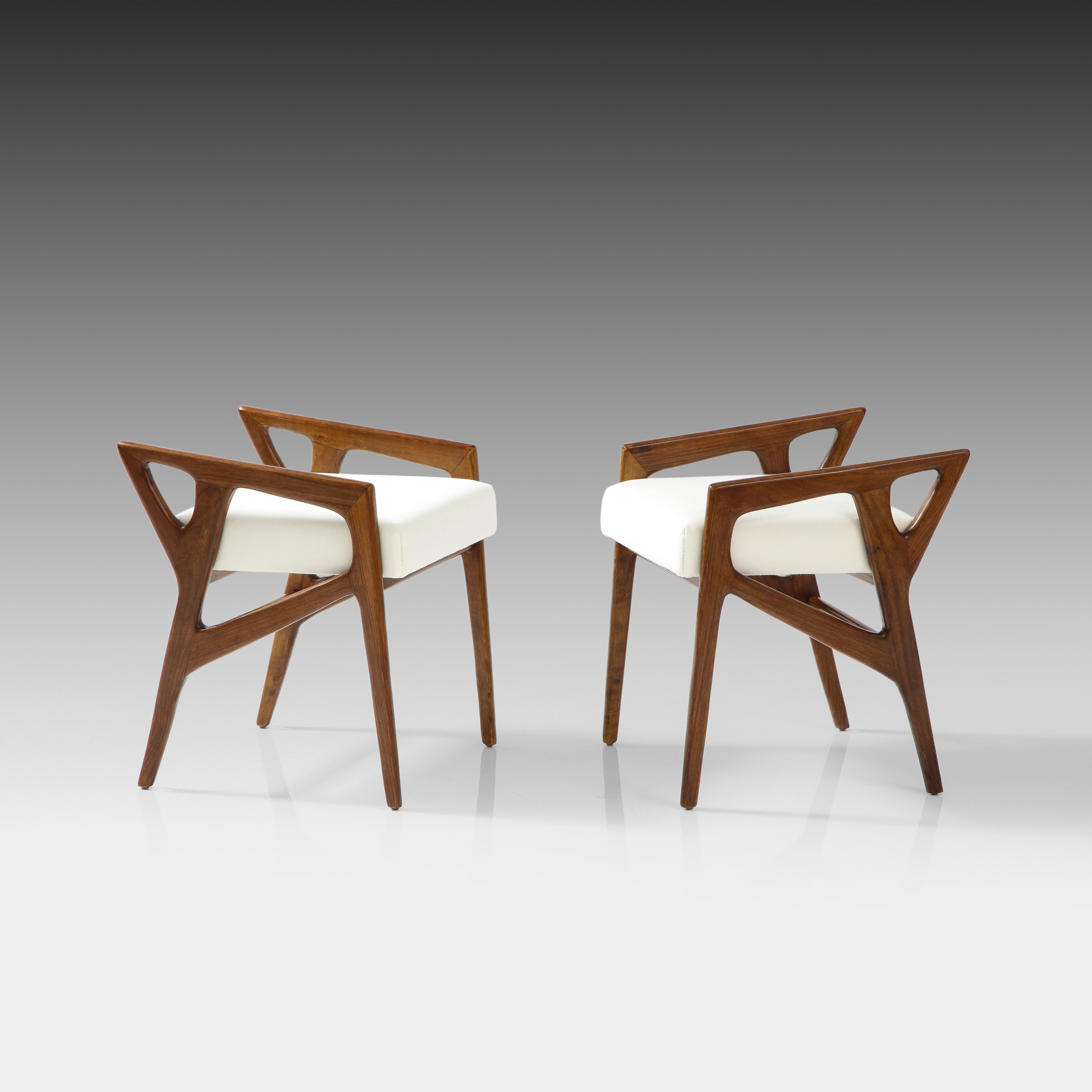 Gio Ponti for Cassina rare pair of sculptural walnut stools, Italy, 1950s. These iconic Ponti stools are an architectural and incredibly chic design which have been restored and reupholstered in a luxurious Holland and Sherry Primo White or ivory