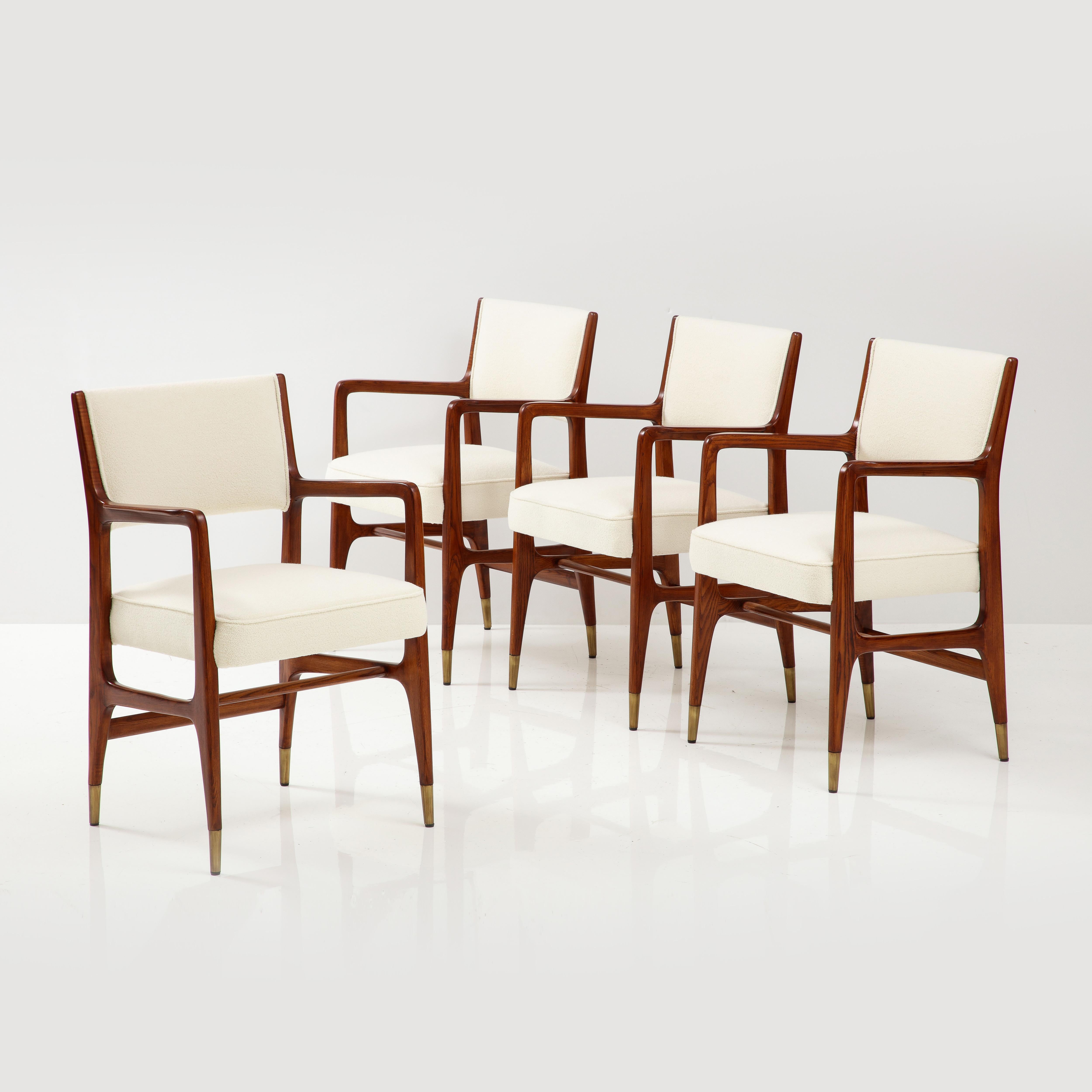 Gio Ponti for Cassina rare set of 4 dining chairs model 110 with white oak frames, upholstered seat and back in ivory bouclé, and ending in brass sabots, Italy, 1950s. These Ponti classic architectural armchairs have sculptural curved armrests,