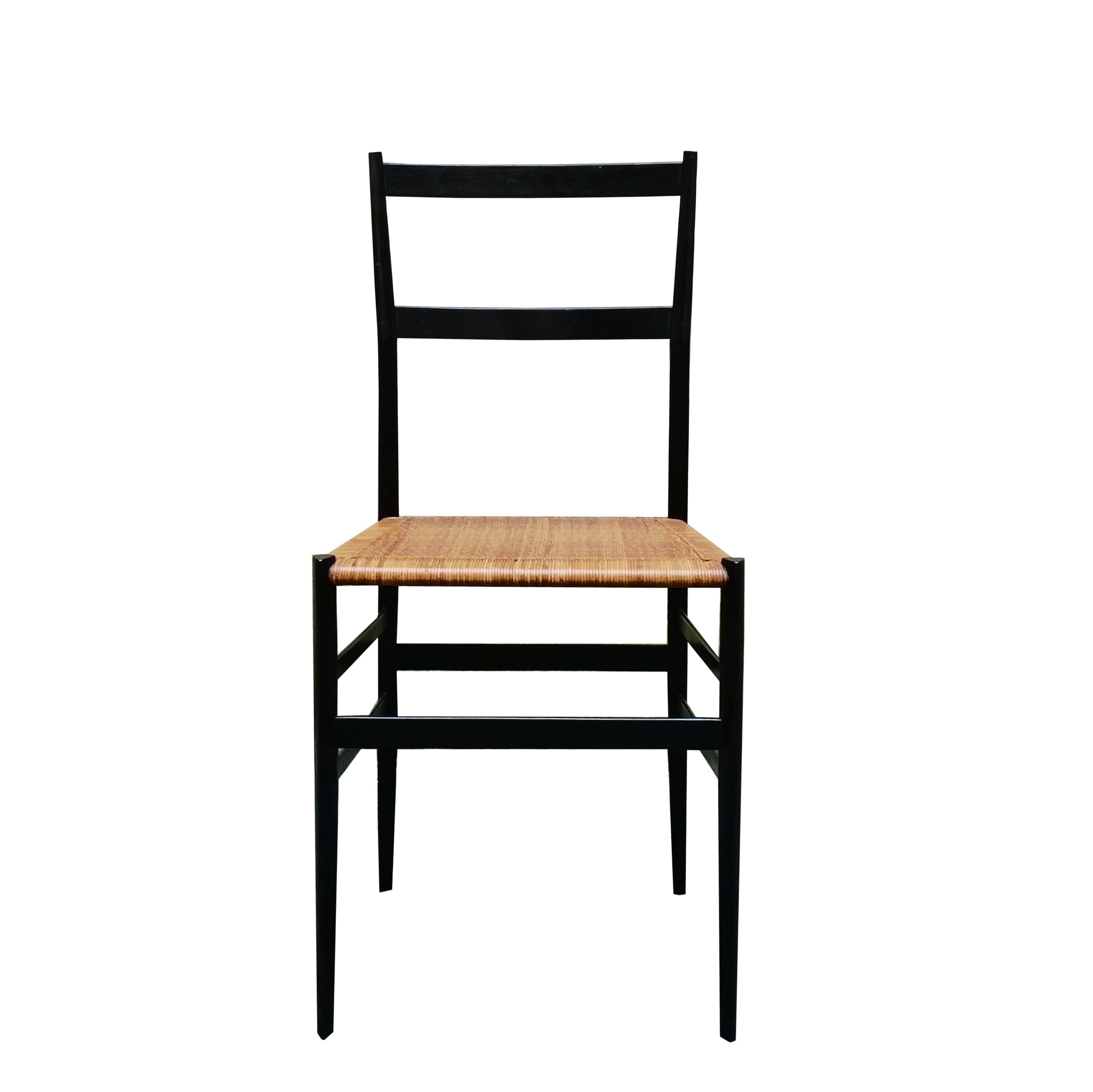 Superleggera chair with black-stained beechwood frame, triangular-section legs, and hand-woven straw seat. Designed by Gio Ponti in 1951 and produced by Cassina.