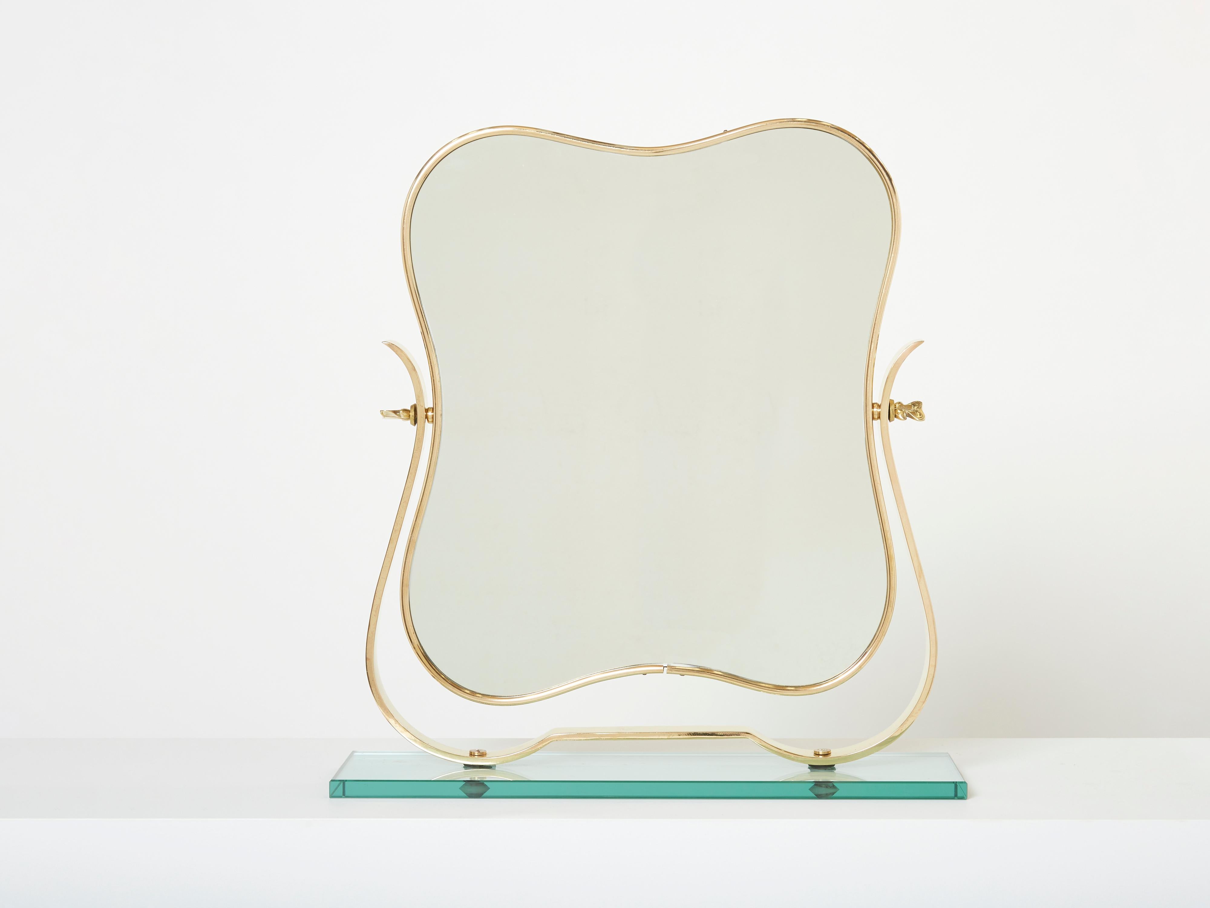 Dieser schöne Tischspiegel aus Messing und dickem Murano-Glas wurde von Gio Ponti entworfen und von Fontana Arte in den 1950er Jahren in Italien hergestellt. Er besteht aus einer Messingstruktur mit einem verstellbaren Spiegelrahmen aus Messing, der