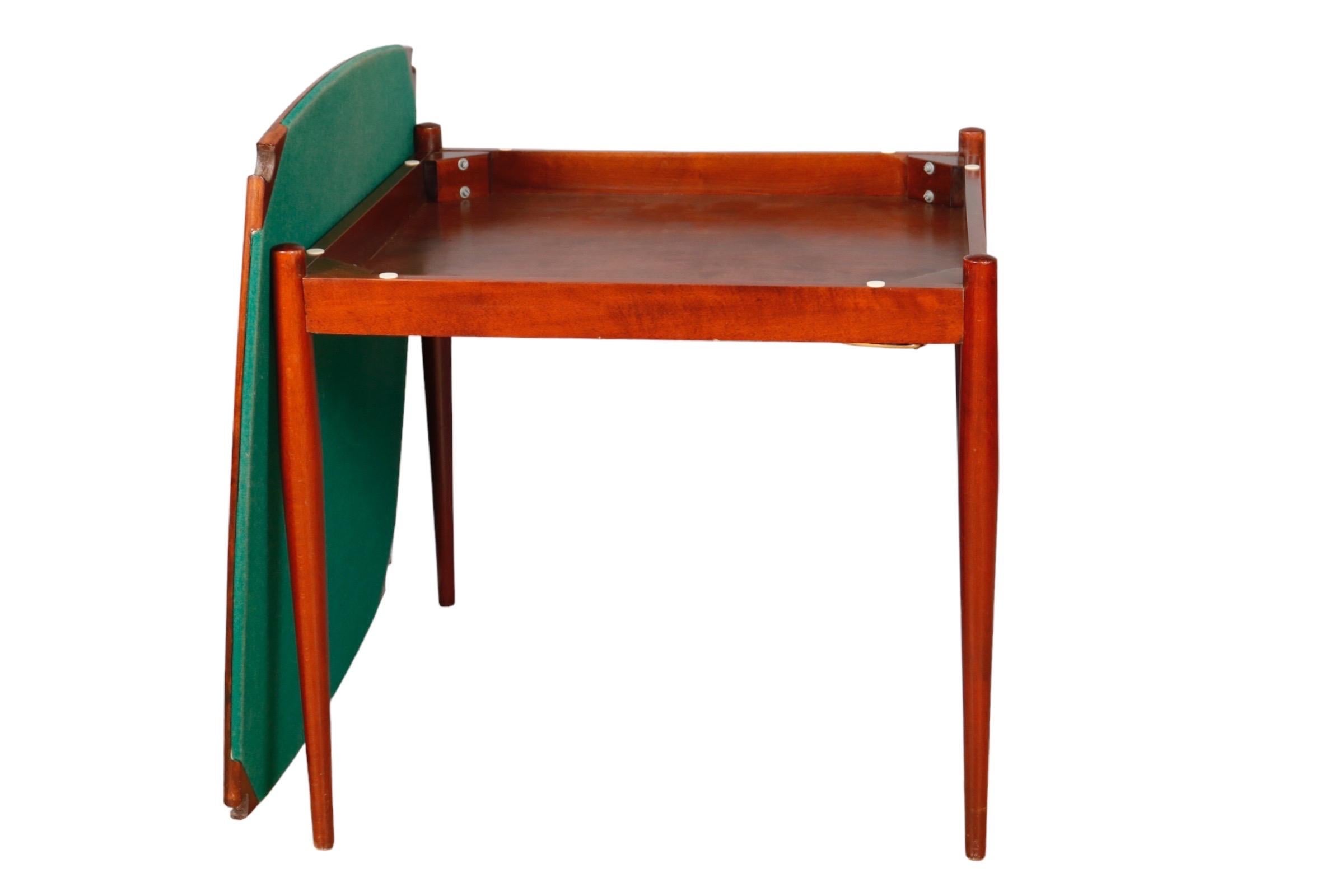A Mid-Century Modern game table in teak, designed by Gio Ponti for Fratelli Reguitti. The table top is reversible with green felt cloth on one side. In the corners are hidden gold brass trays that rotate out.

Creator Gio Ponti
Manufacturer