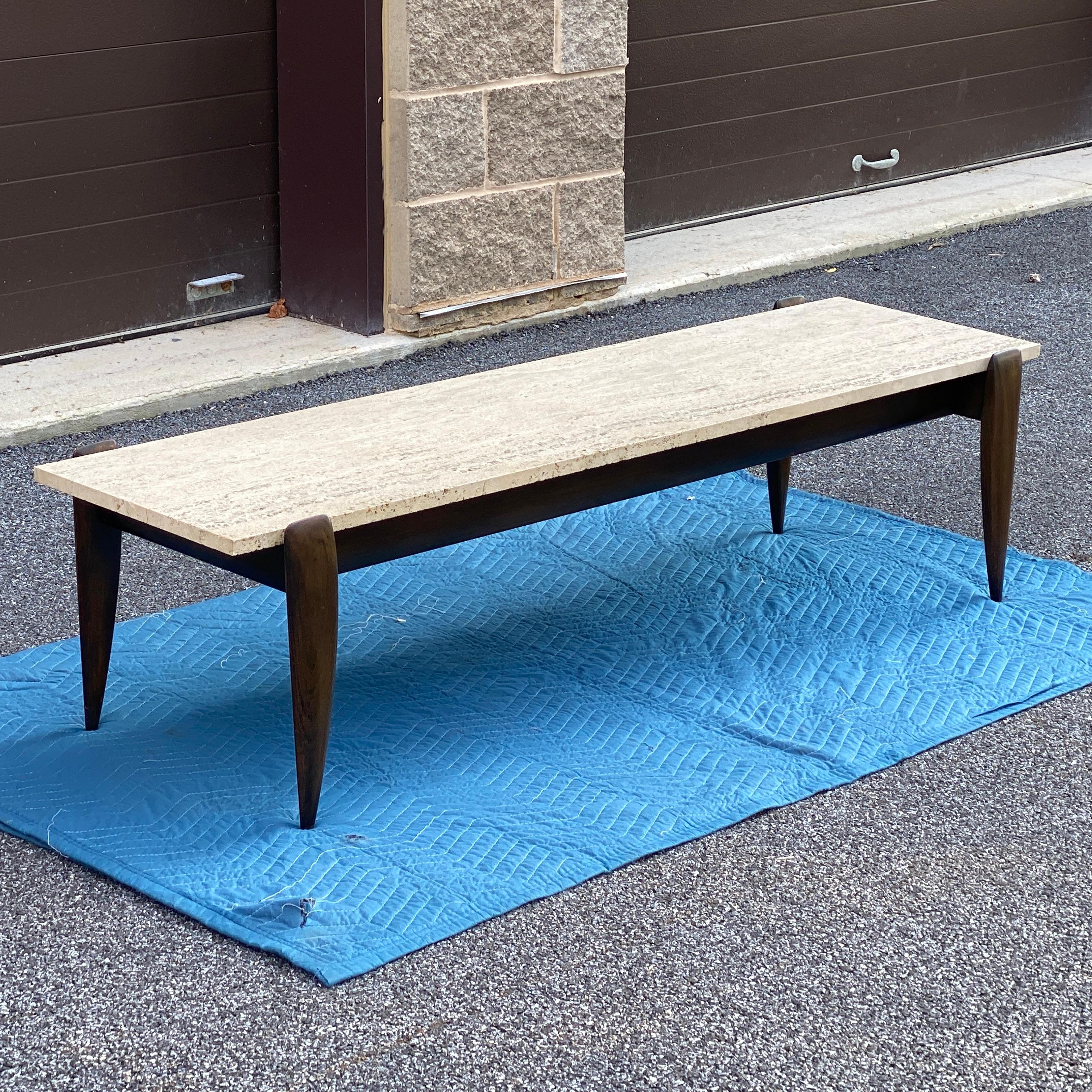 Mid-Century Modern coffee table with a travertine top on a sculptural solid walnut base. Top measures 60” x 15 7/16” x 3/4”. Designed by Gio Ponti for M. Singer & Sons circa 1950s unmarked.