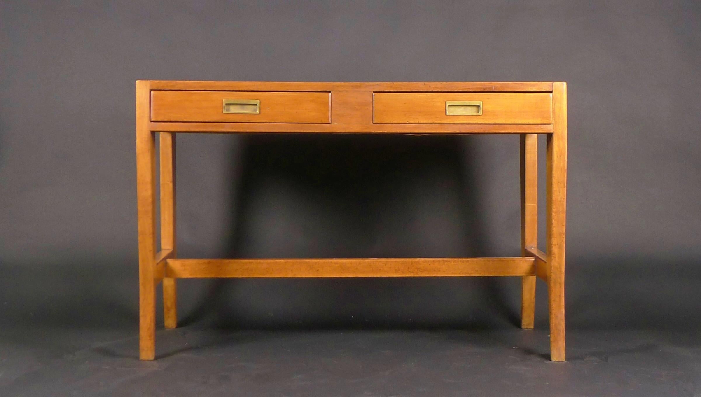 Gio Ponti desk in light walnut with brass countersunk handles, on shaped tapering legs united by stretchers.  The wood is in excellent condition with beautiful graining to the planked top, and the two drawers to the front slide smoothly.  120cm