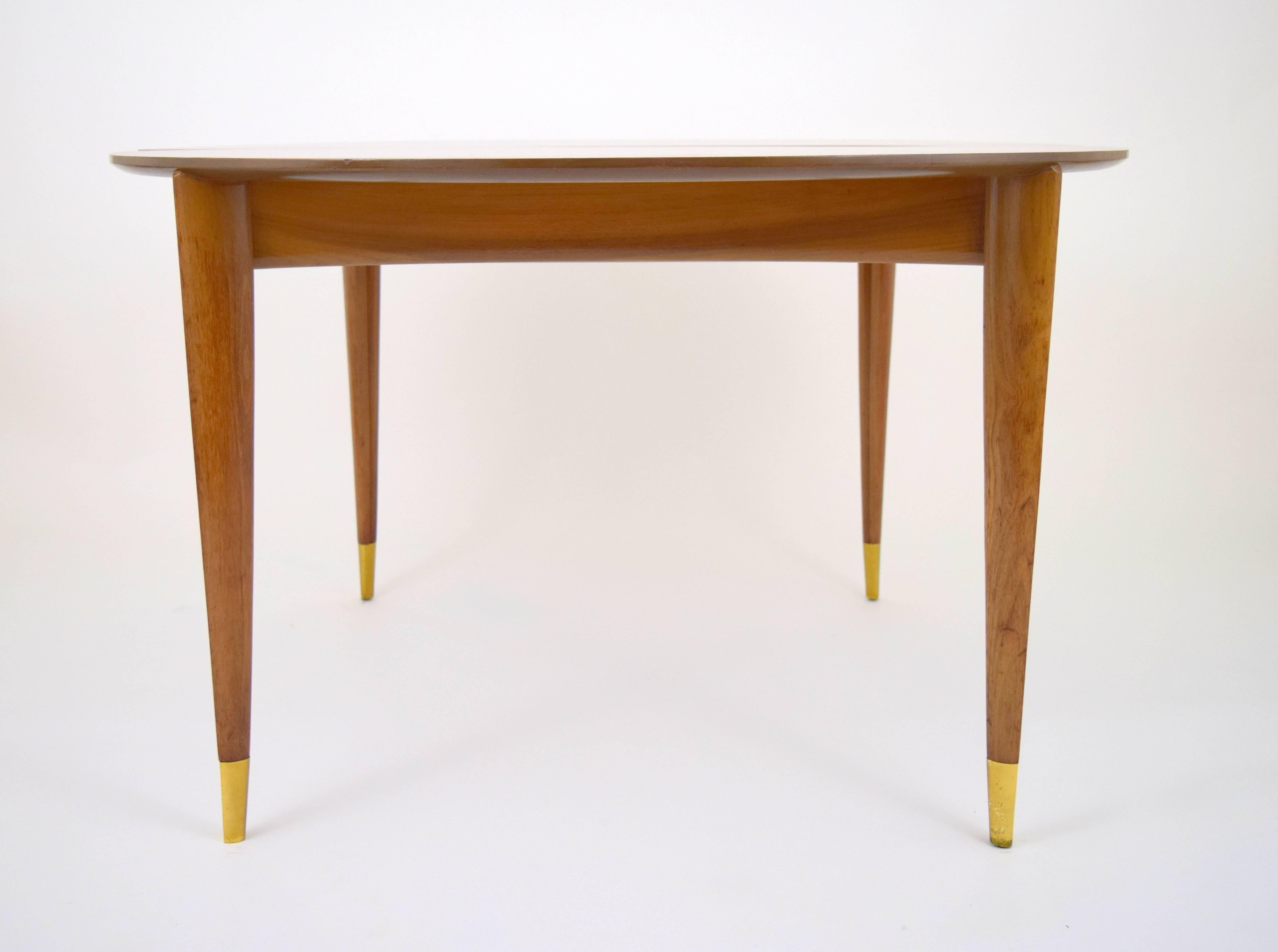 Graceful Gio Ponti walnut dining table for M. Singer and Sons. Beautiful graining throughout, elegantly tapered triangular form legs with solid brass ferrules, gently concaved apron. Four 14