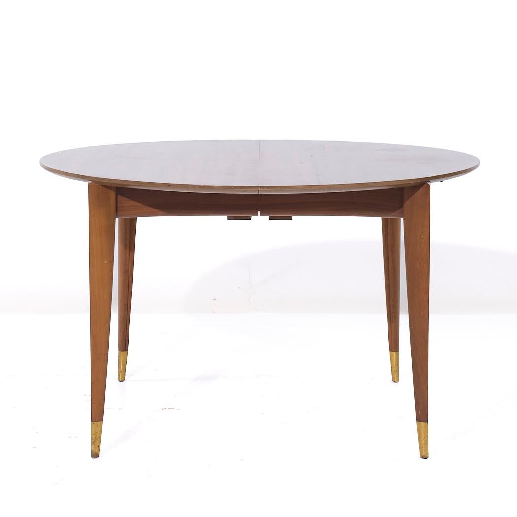 Gio Ponti for Singer and Sons Model 2135 Mid Century Walnut Expanding Dining Table with 4 Leaves

This table measures: 48 wide x 48 deep x 28.75 inches high, with a chair clearance of 27.75 inches, each leaf measures 14 inches wide, making a maximum
