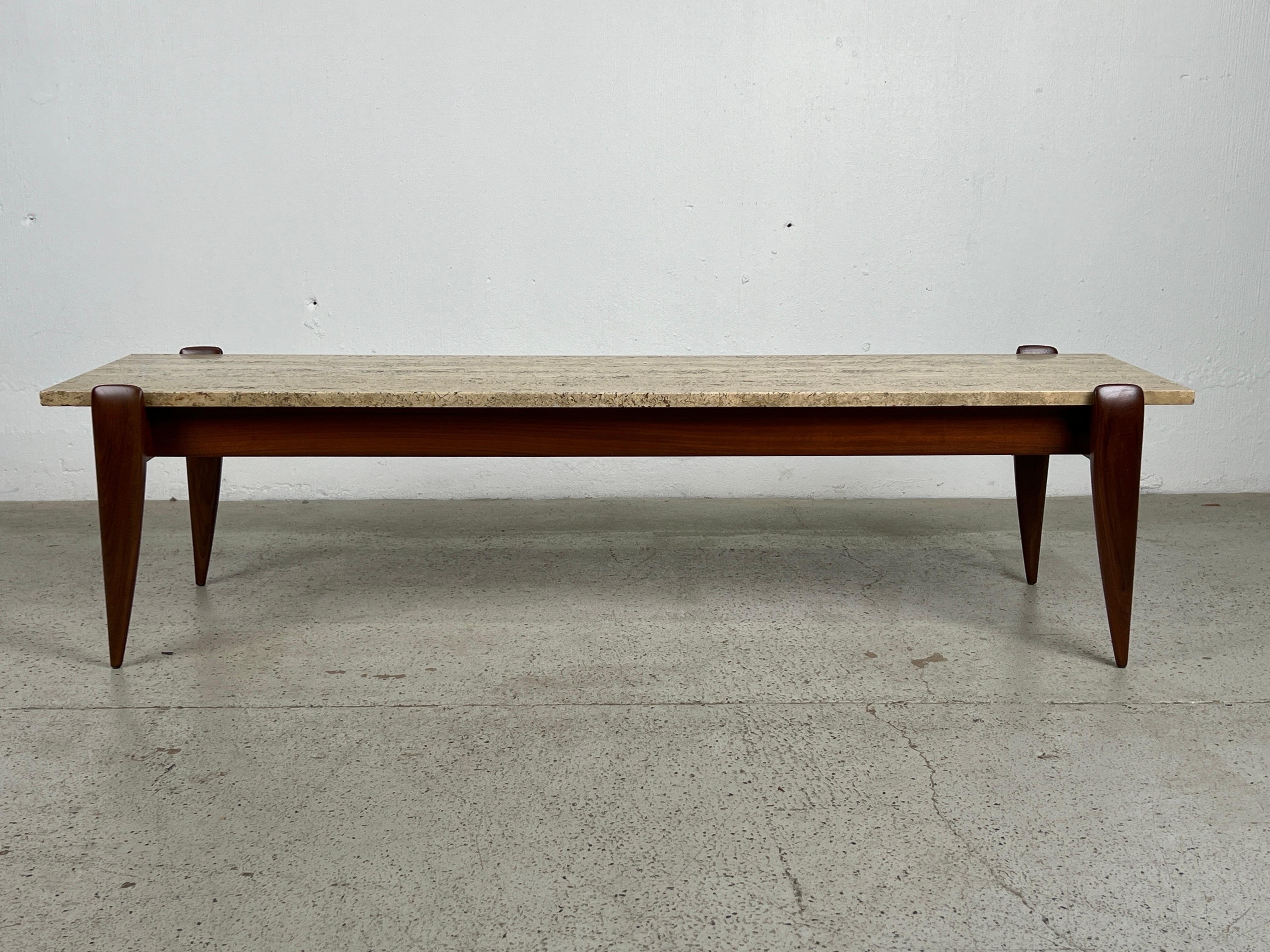 A walnut table with original travertine top. Designed by Gio Ponti for M. Singer & Sons. 