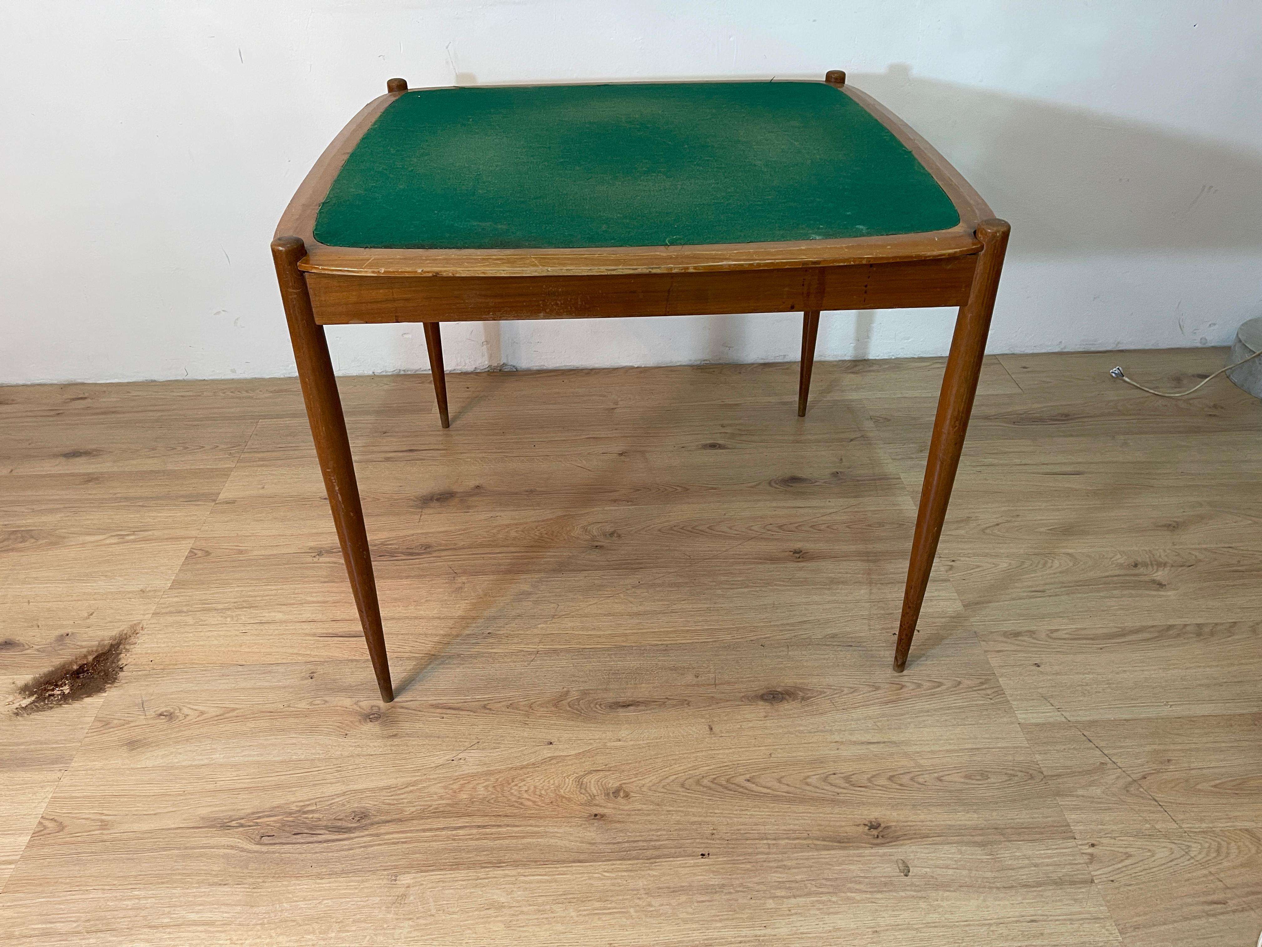 Spieltisch mit wendbarer Platte, eine Seite mit grünem Stoff für das Spiel und ein Teil mit Holzoberfläche als normaler Esszimmertisch. Der Tisch ist ein berühmtes Werk des größten italienischen Designers Giò Ponti, der ihn für das ebenso berühmte