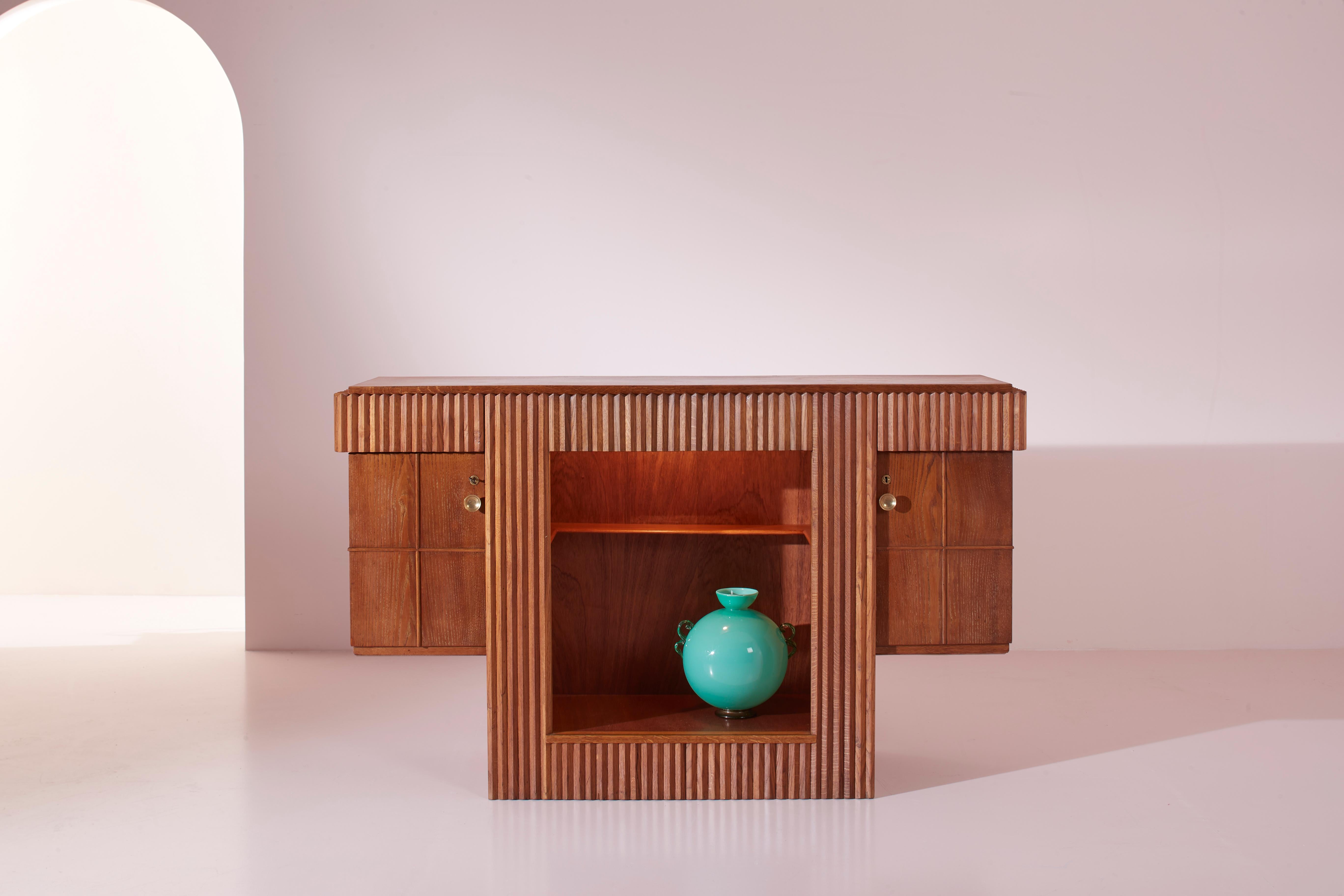 Meuble bar avec étagères et portes en bois de chêne, artisanat italien des années 1940, conçu par Gio Ponti.

Ce mobilier en chêne, parfait pour une réception ou un salon d'accueil, se distingue par sa personnalité et devient immédiatement le point