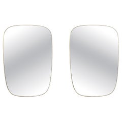 Gio Ponti, in the style of. Pair of mirrors framed in gilt brass. 1980s