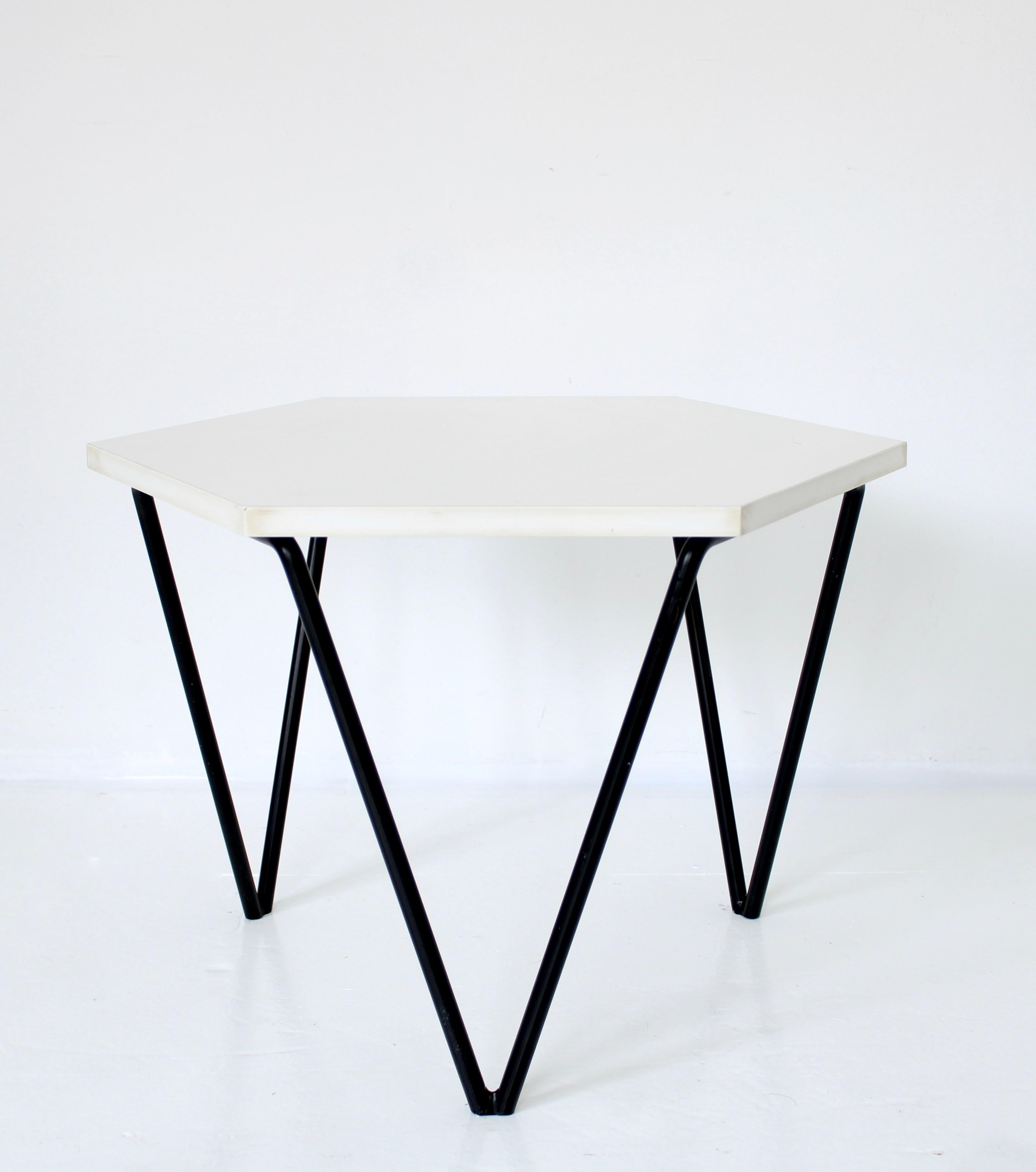 Modular segmented coffee tables designed by Gio Ponti. 7 identical tables either made of wood, black or white laminate. Each had a honeycomb shape and three triangular legs. The metal bases has their original black powder coat paint, tabletop is