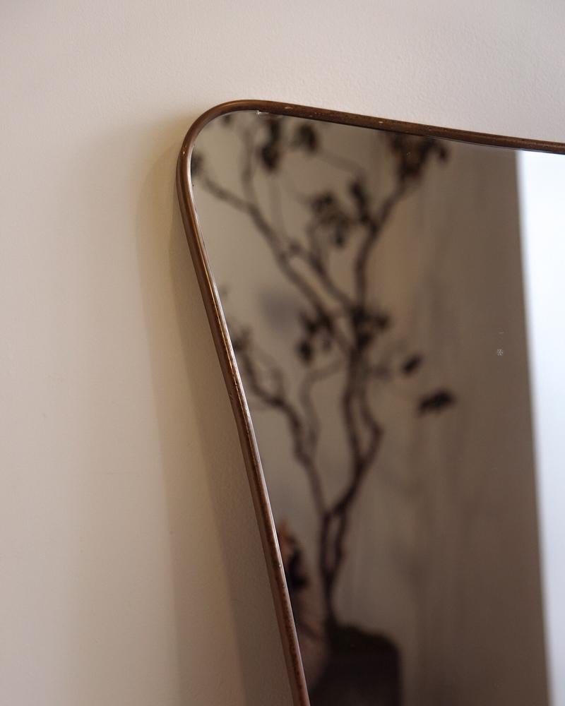 Large brass wall mirror with curved detailing by Gio Ponti and manufactured by Fontana Arte. Brass is nicely patinaed. 