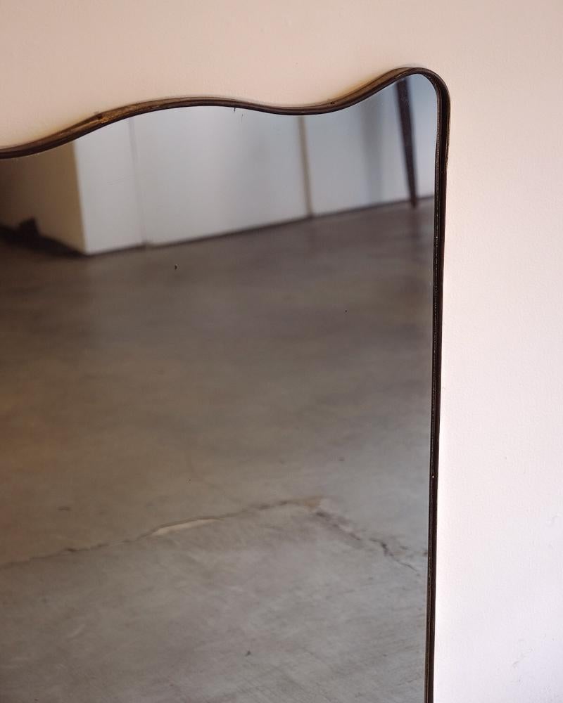 Large brass wall mirror with curved detailing by Gio Ponti and manufactured by Fontana Arte. Brass is nicely patinaed. 
