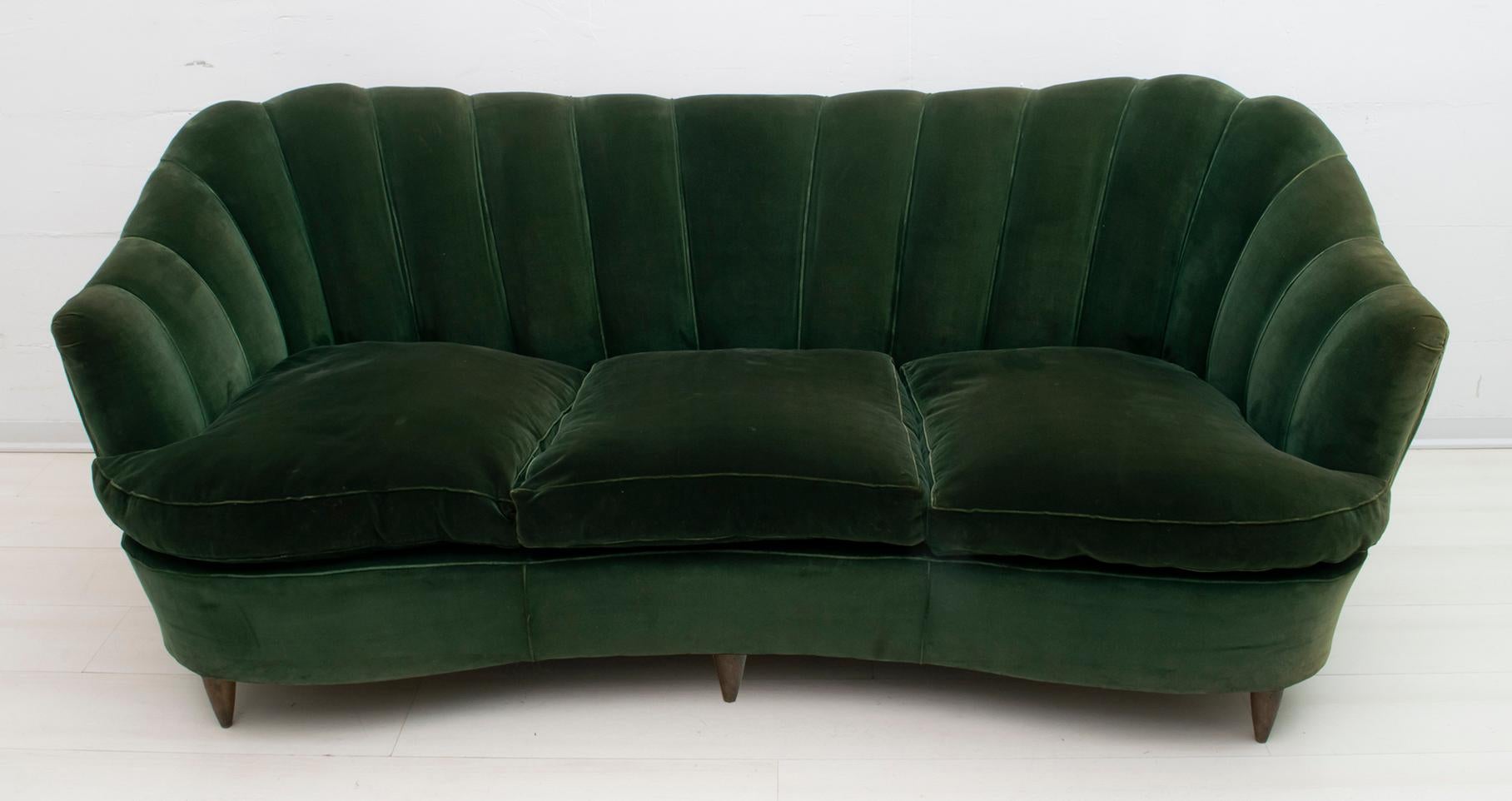 A rare sofa by Gio Ponti for Home and Garden, 1936.
Shell model covered in original green velvet of the time, with goose down cushions. The coating, as shown in the photo, has faded in some parts.

With an additional cost we can provide for