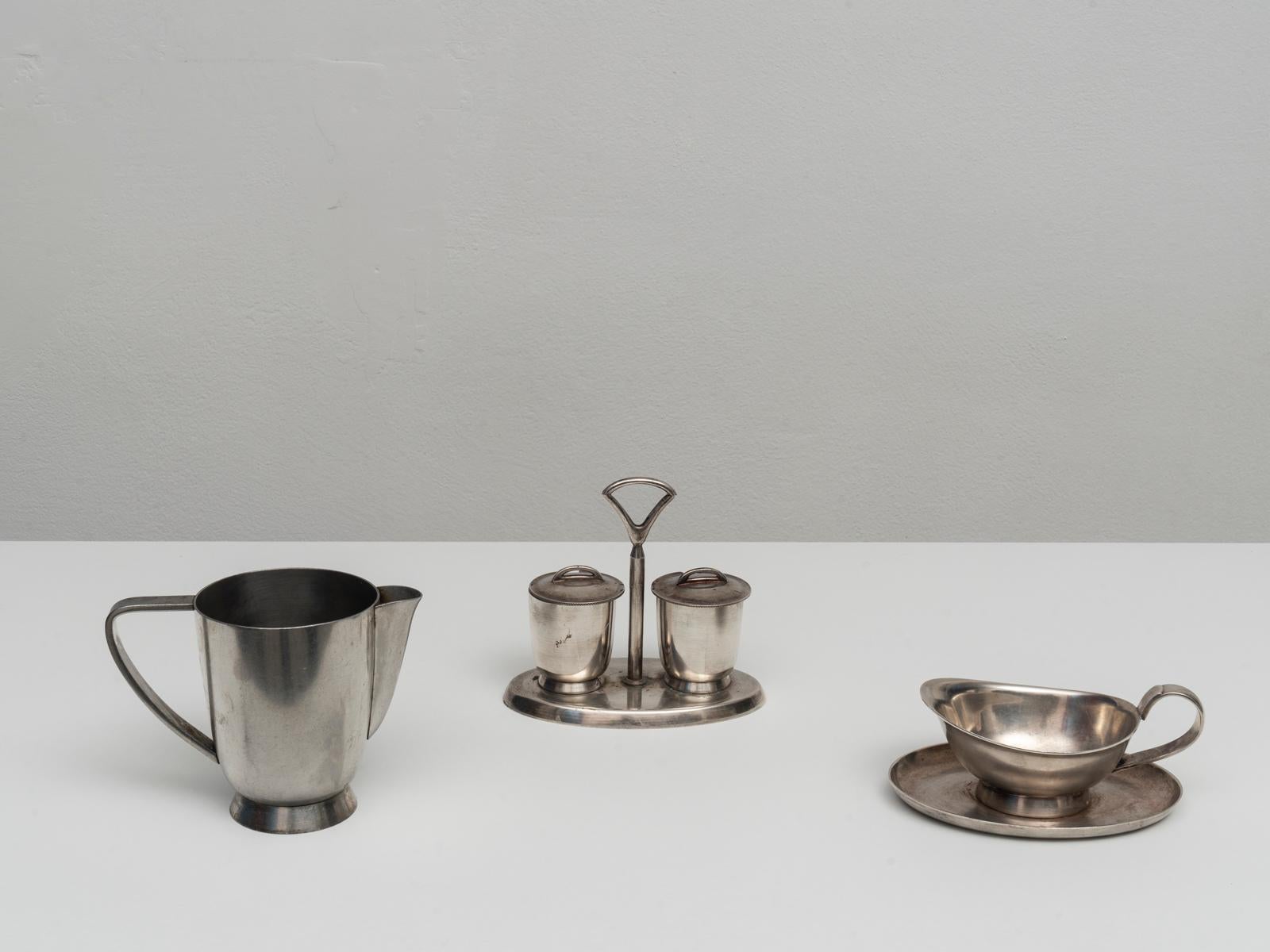 This serving set was designed by Gio Ponti for Fratelli Calderoni in the 1950s. It is made of silver plated alpaca, an alloy of copper zinc and nickel. 
The set includes a milk jug, a sauce bowl and a salt and pepper container. 
This series was used