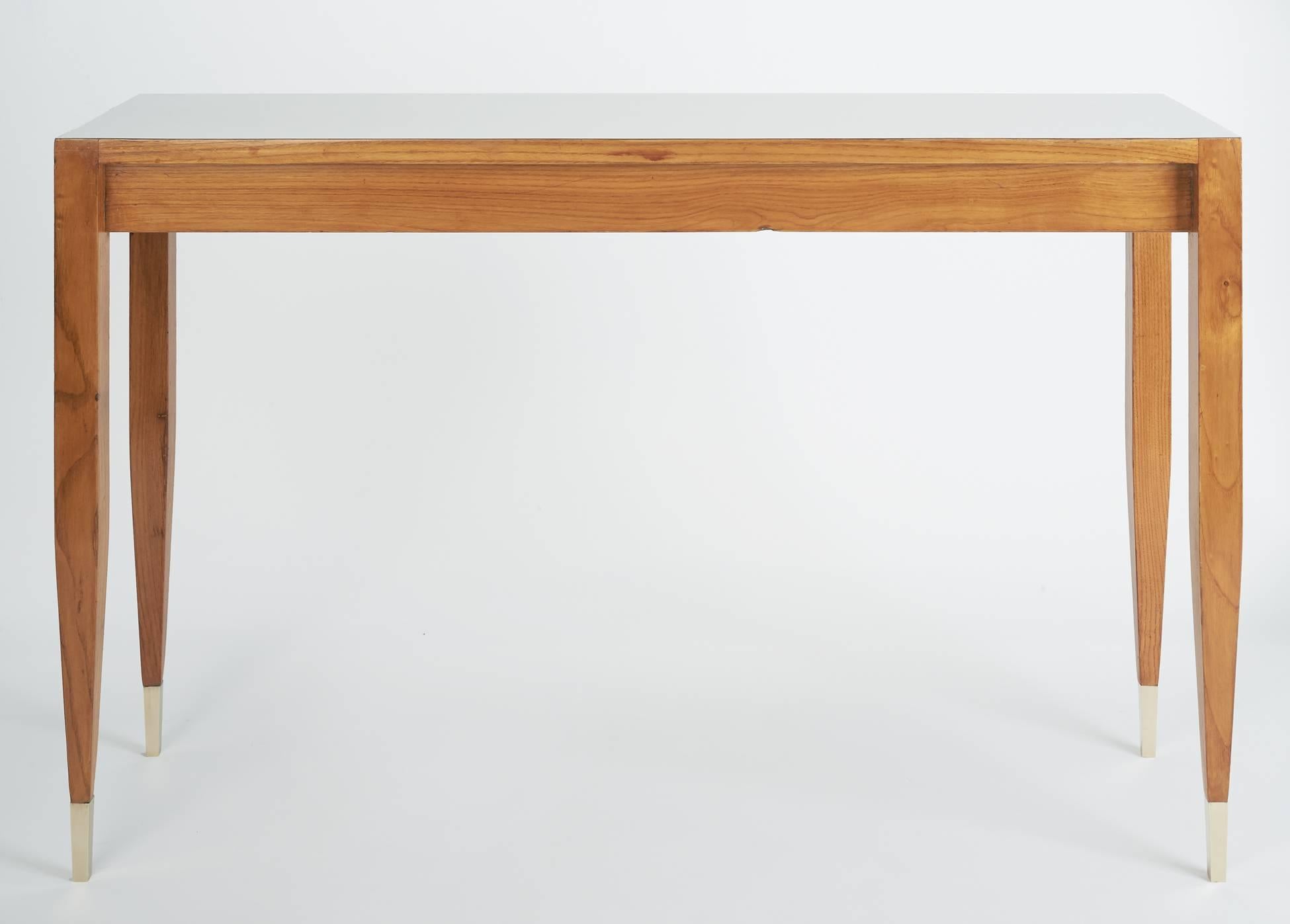 Gio Ponti (1891–1979)
A pure-lined console table with a smartly recessed core and slender, sharply tapered legs by Gio Ponti. In blond ash with brass sabots and an eggshell-colored laminate top, for the Hotel Parco dei Principi. At once functional