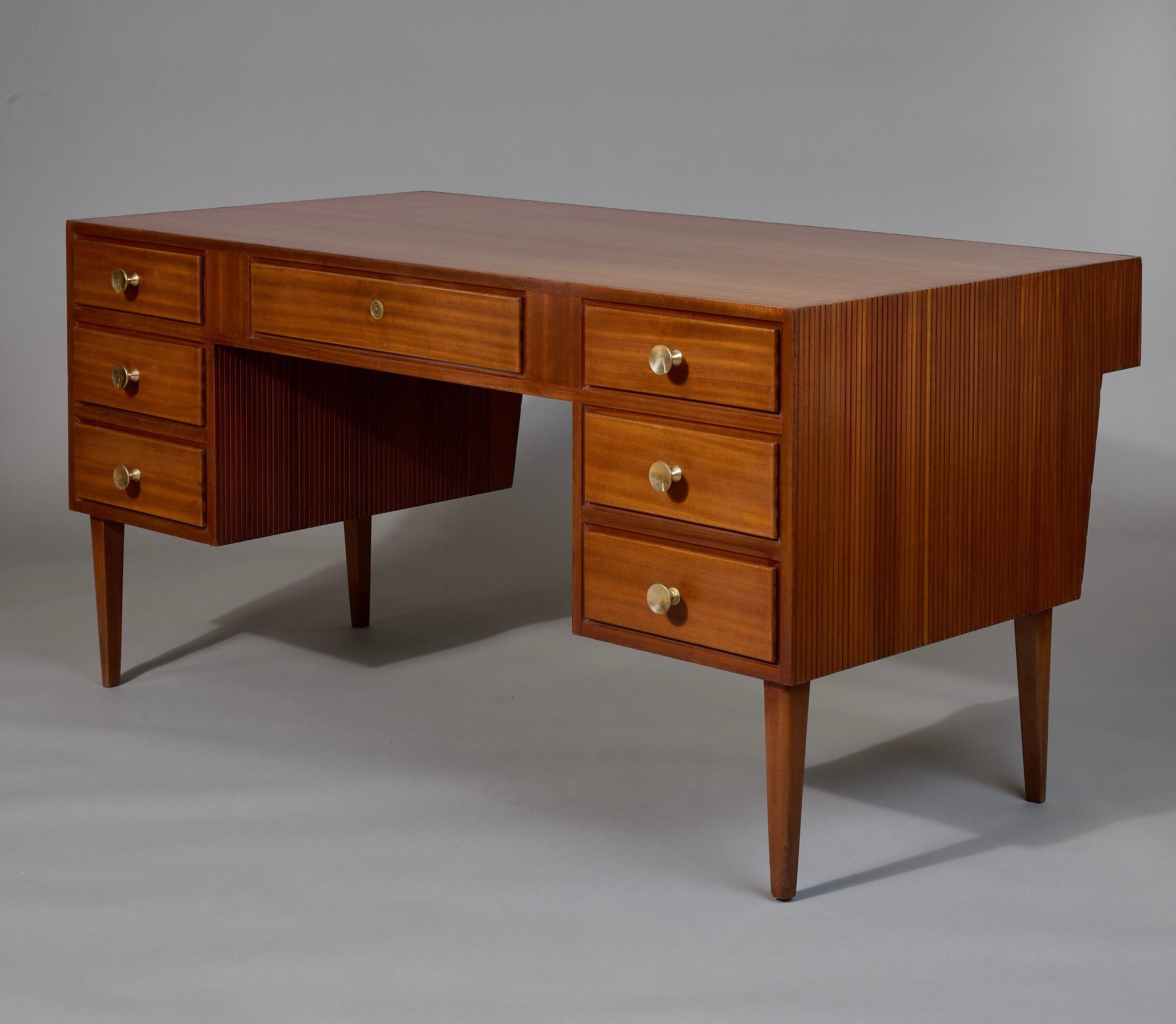 Gio Ponti (1891-1979)

A rare and important executive desk by Gio Ponti, in dramatically carved and reeded walnut with polished brass details. Impeccably crafted, starkly geometric in composition, and imposing in size, this significant work by