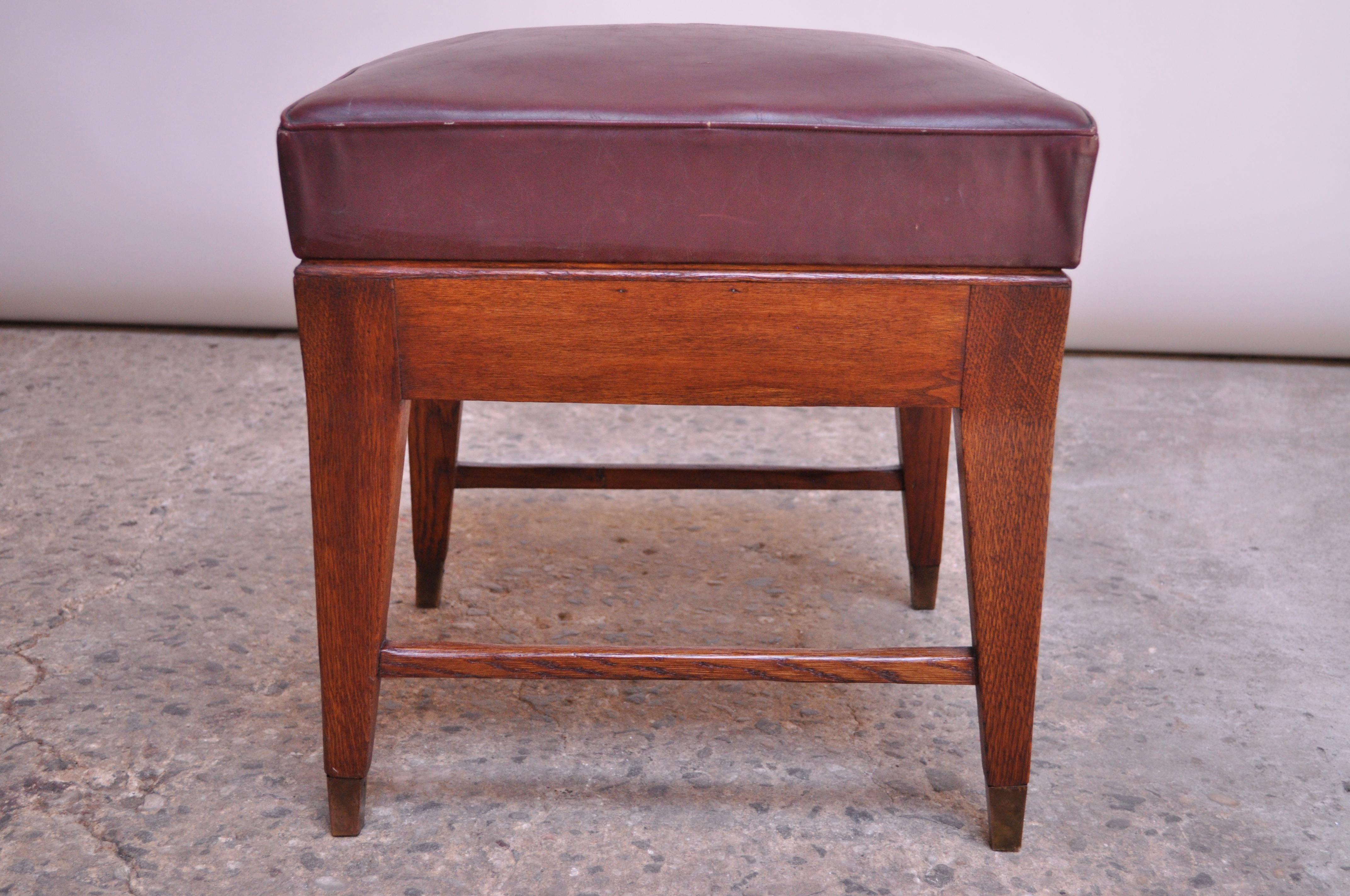 1950s Gio Ponti stool from the University of Brescia in oak with original brass sabots and plum leather seat. Wear consistent with age (spots / wear to the leather, tarnish to unpolished brass, and general wear to oak). Given the importance of the