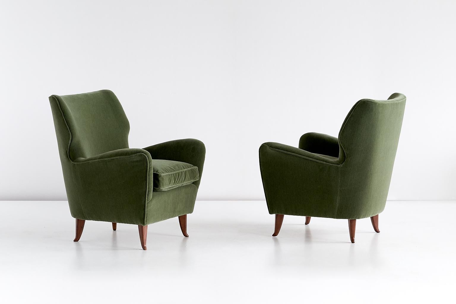 This pair of armchairs was designed by Gio Ponti in 1949. This particular model was manufactured for the Hotel Bristol in Merano, Italy. 
The rounded lines and the curved, tapered legs in walnut wood give the chair a refined appearance. The chairs