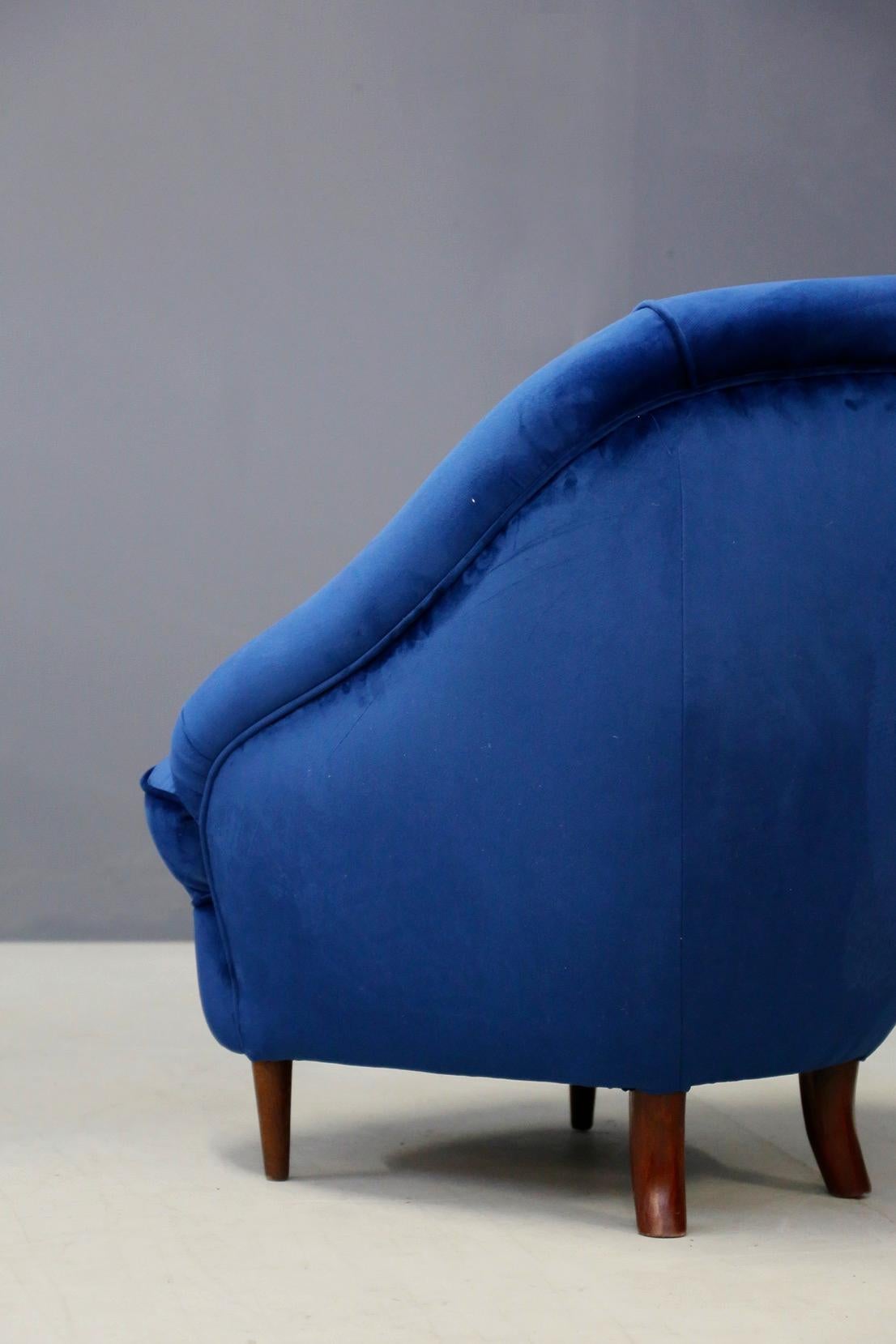 Beautiful pair of armchairs from the 1930s by Gio Ponti. The armchairs have been restored in blue Italian velvet. Curved armchairs upholstered in antique velvet with Italian walnut legs. The pair of armchairs. Antiqued velvet upholstered curved
