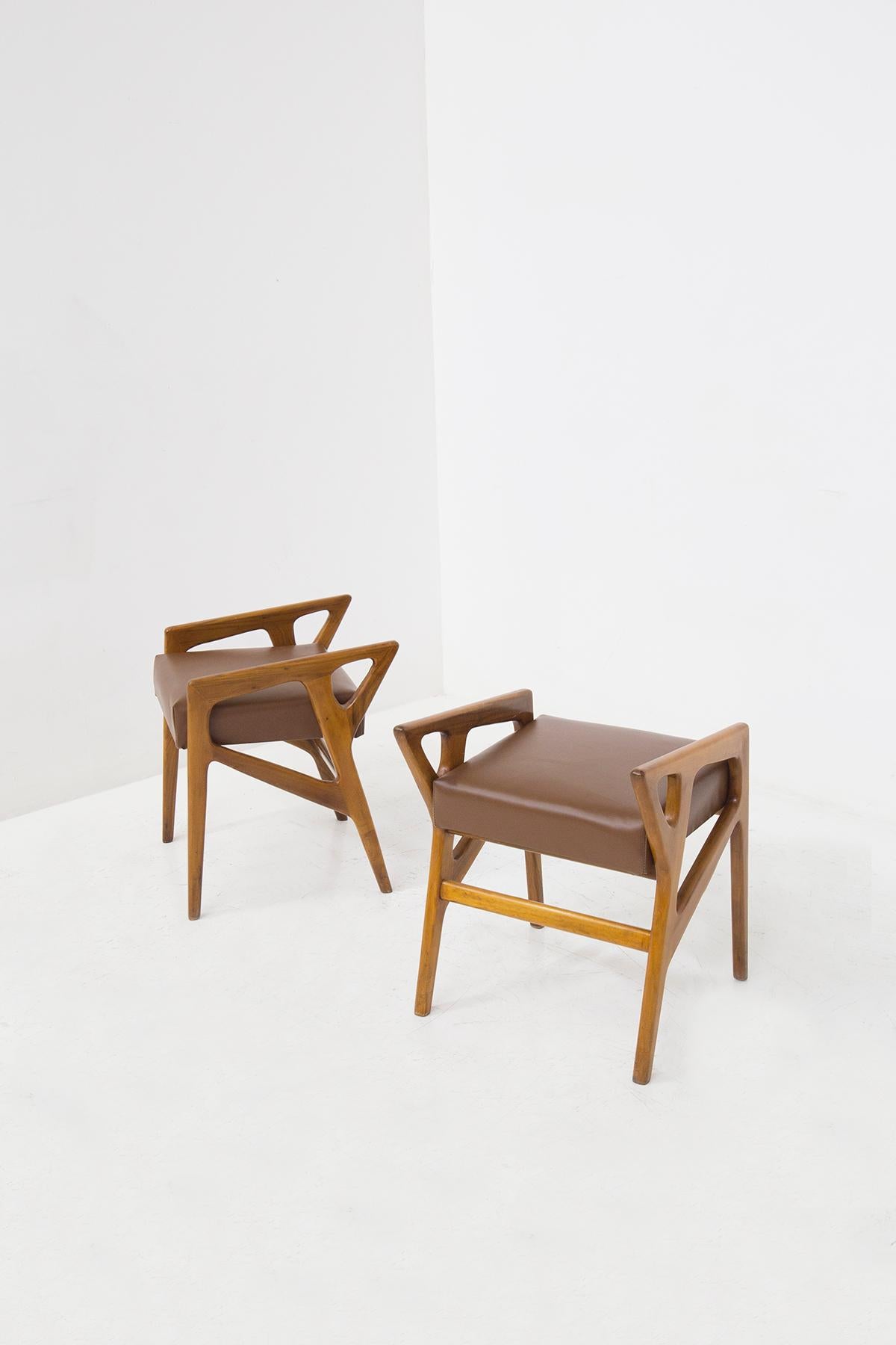 Magnificent pair of stools by the great Architect Gio Ponti, 1950's. The pair of stools has an ORIGINAL brown leather seat, in perfect condition. The stools have clean geometric shapes that create a striking strict defined line that vibrates upward.