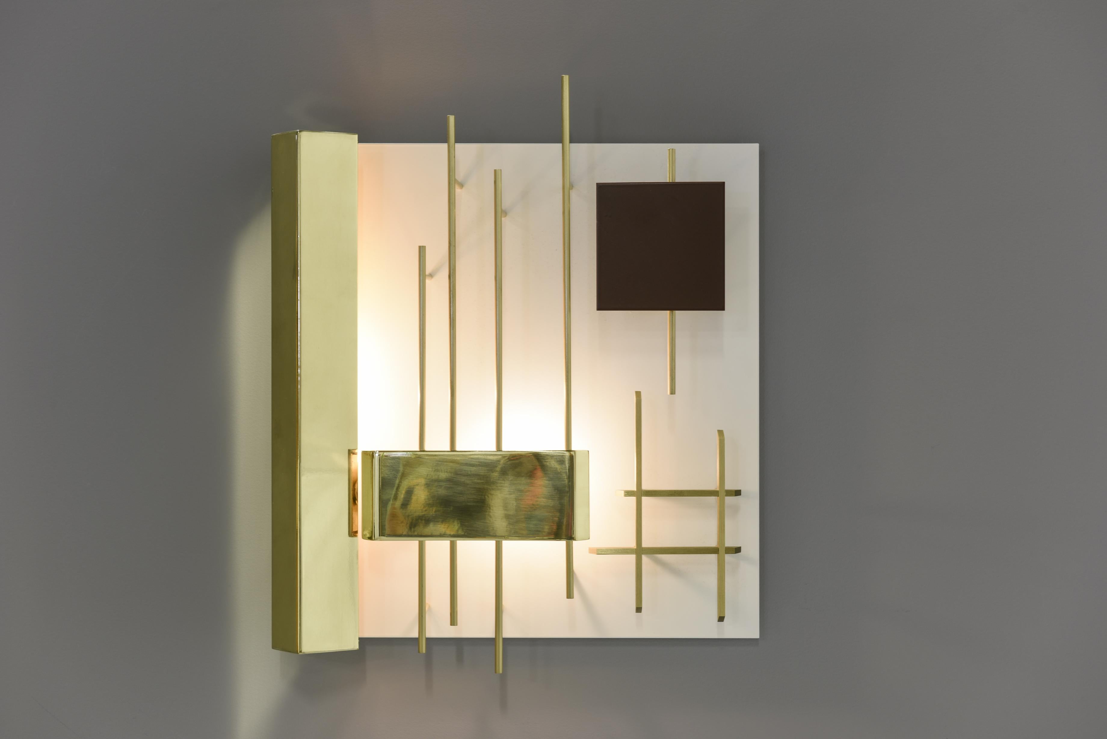 Elegant square wall sconces by the one of the famous designer and architect from Italy.
Very graphic lamps in brass and metal lacquered. The light hidden on the left side creates play of light on the lamp and wall.

Signed with applied brass