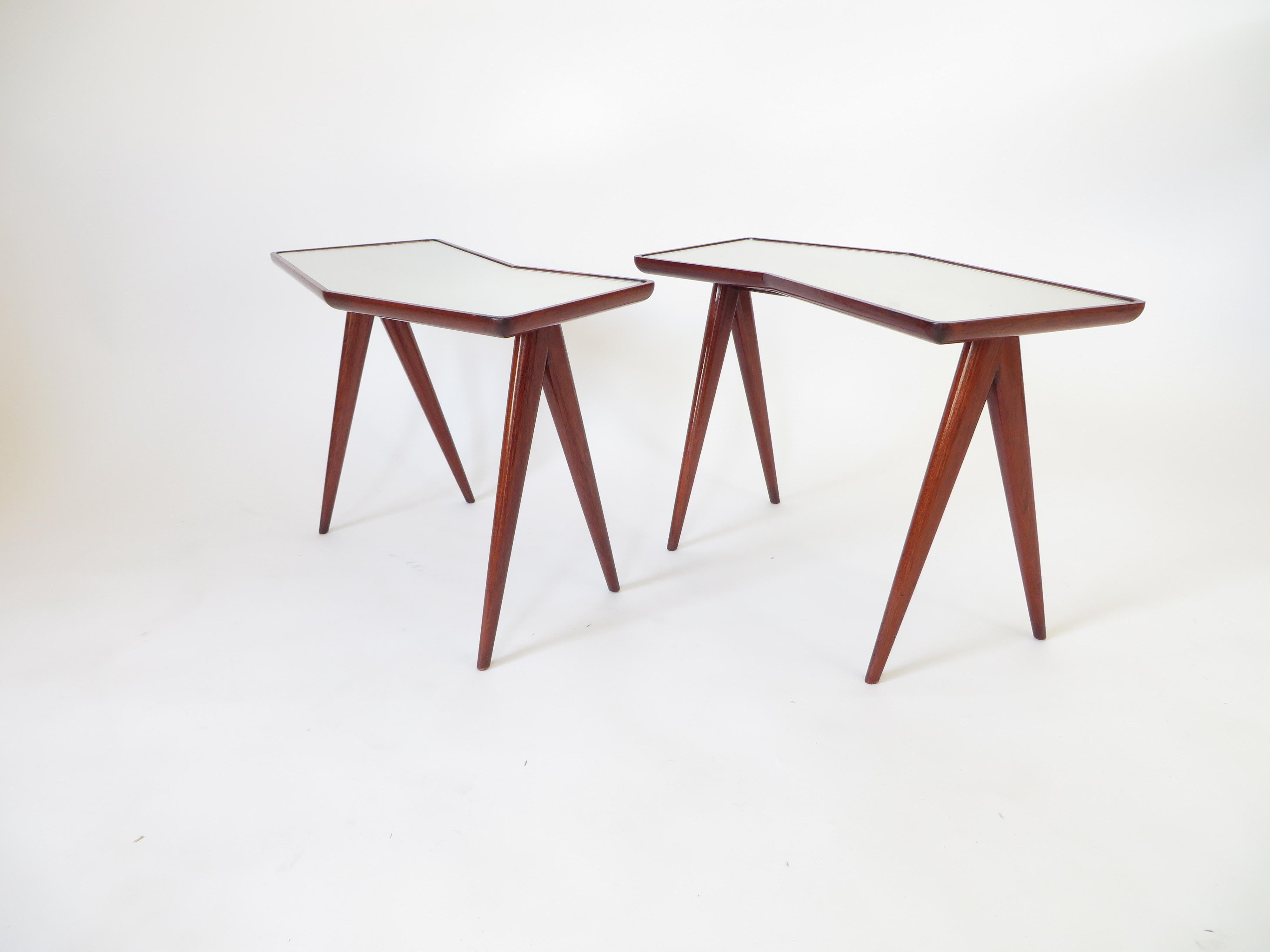 Pair of Italian master architect Gio Ponti compass legs side tables with mirrored glass tops by Pietro Chiesa. All original.
The slightly mirrored glass reflects the light and whatever is positioned on it.
The legs splay in iconic Ponti fashion and