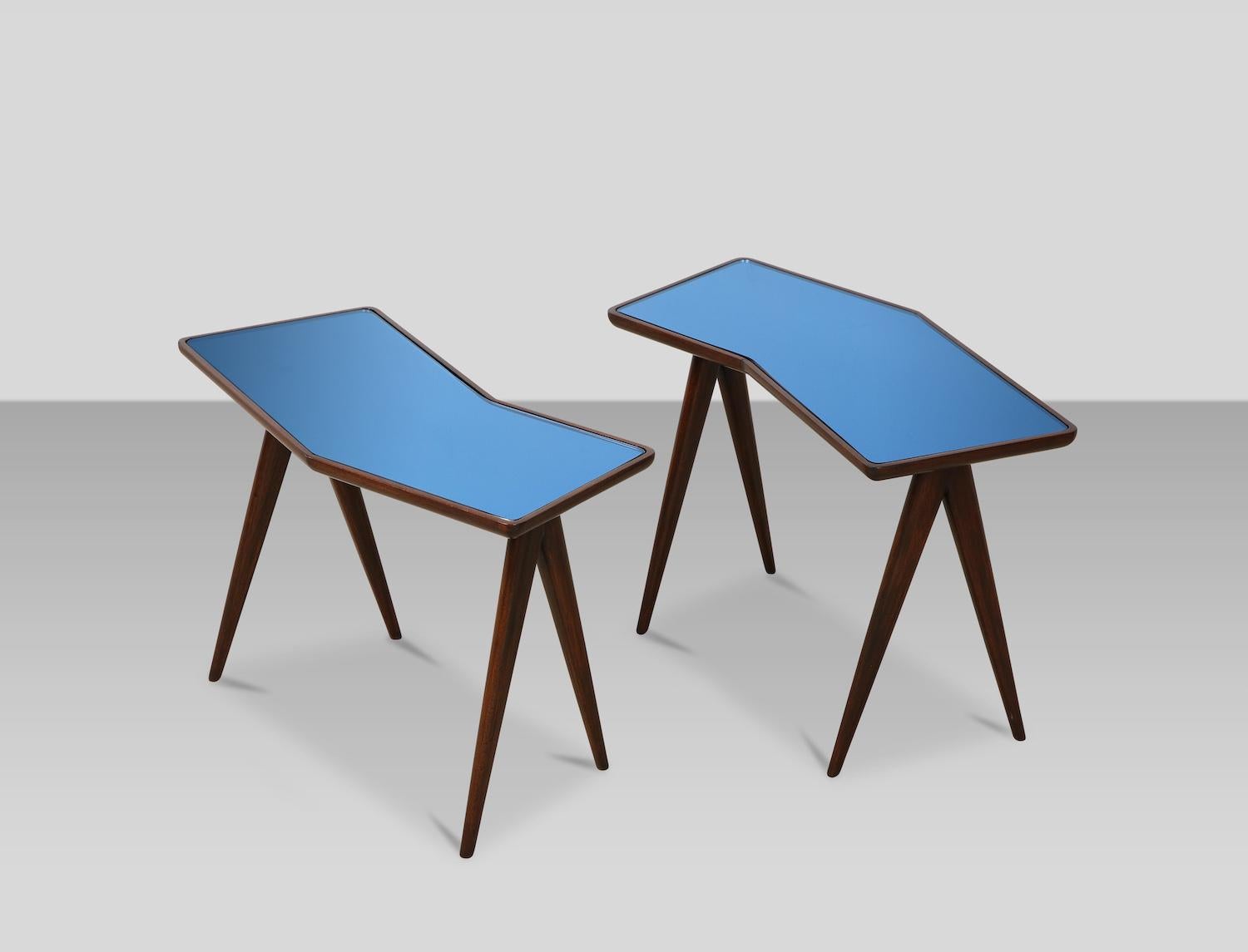 Rare pair of side tables by Gio Ponti & Pietro Chiesa. A collaborative design effort by Ponti & Chiesa, & produced by Fontana Arte. Petite pair of tables with compass legs, and angled tops inset with sapphire-blue mirror panels. Wood has recently