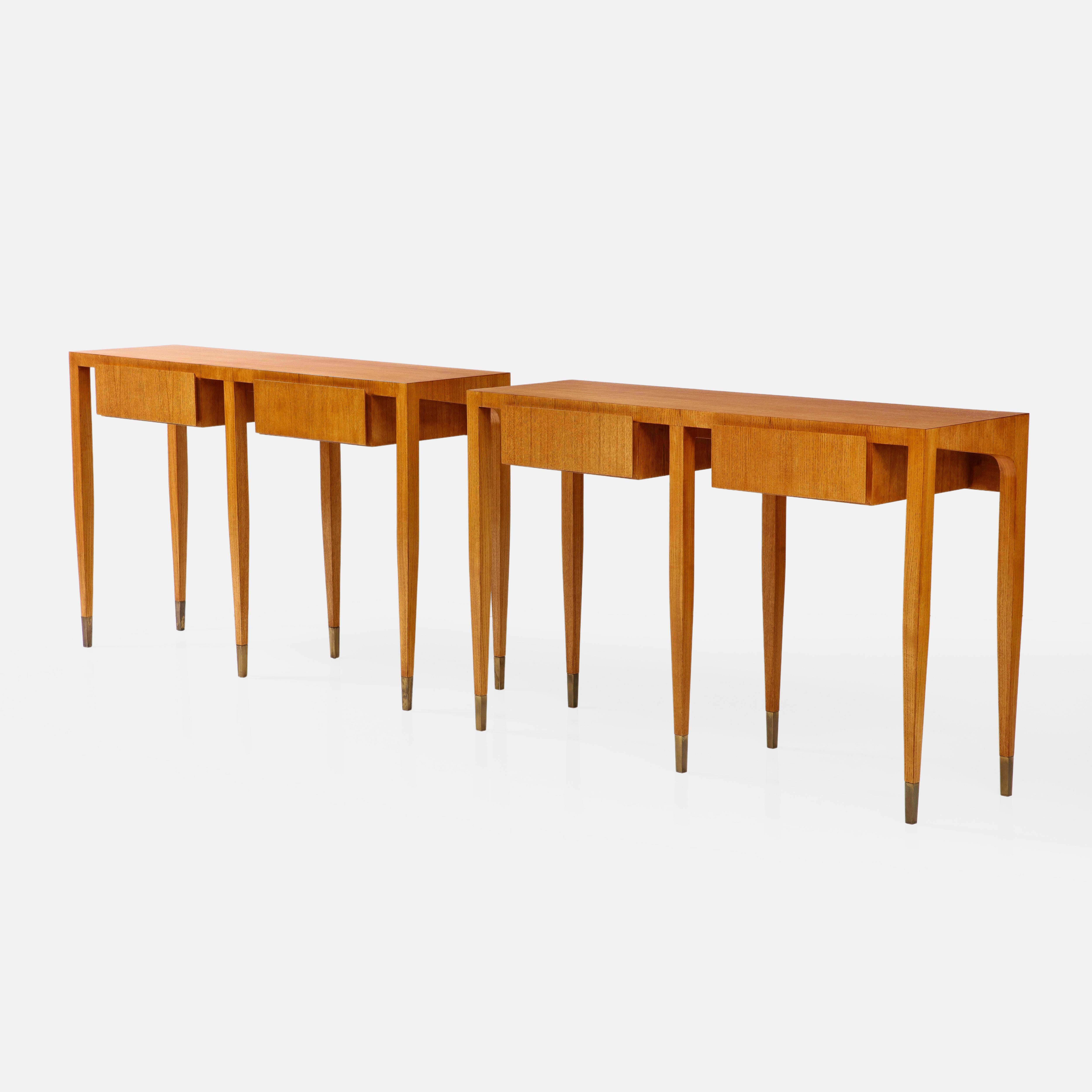 Gio Ponti for Giordano Chiesa rare and important pair of ash wood console tables each with two drawers and six legs ending in brass sabots, Italy, circa 1955.  These exquisite sculptural consoles have fine details throughout and clean architectural