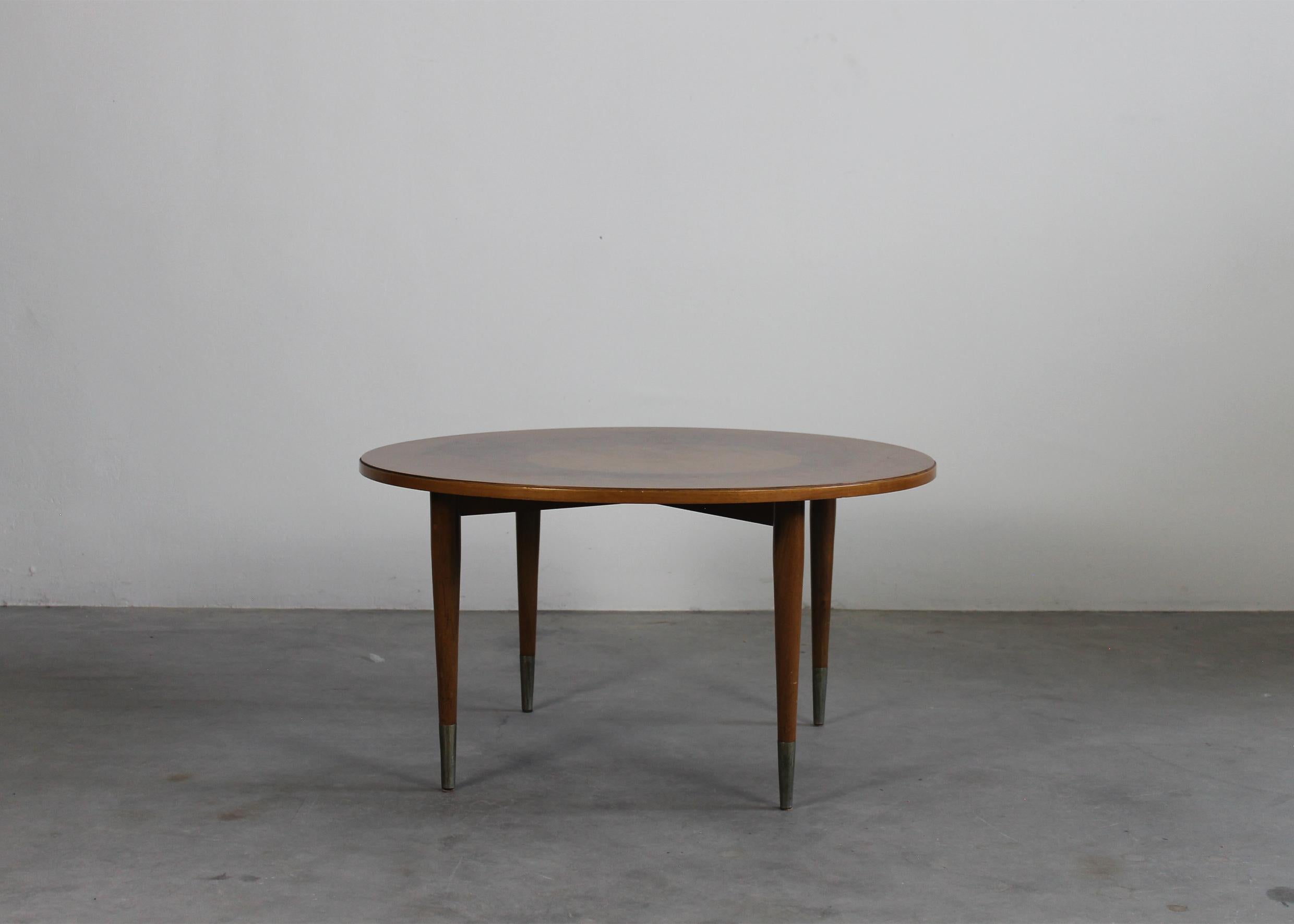 Round coffee table realized in walnut wood with metal details, the tabletop presents an elegant circular decorative motif. 

Attribuited to Gio Ponti, Italian manufacturer from the 1950s 

Gio Ponti was an icon of the modernist movement: the Italian