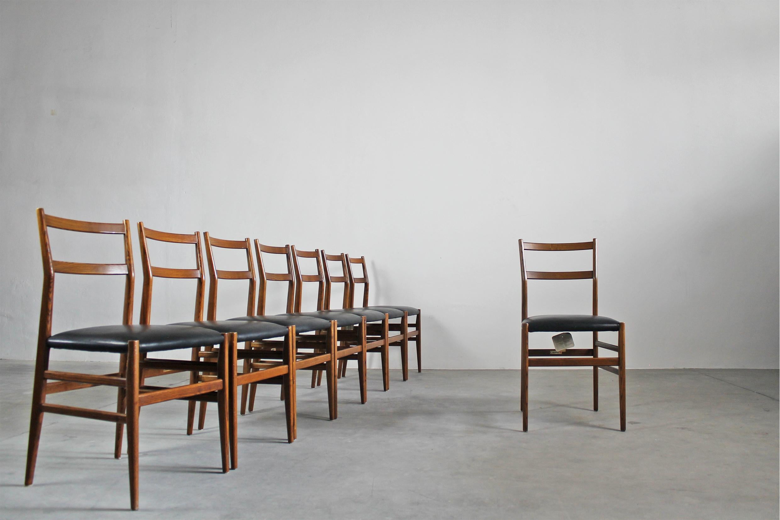 Set of eight Leggera dining chairs with a wooden structure and seat upholstered in black leather, designed by Gio Ponti for Cassina, 1970s. 
Leggera is a simple chair, with a polite, clear, cultured shape, strong in its past as a design icon. The